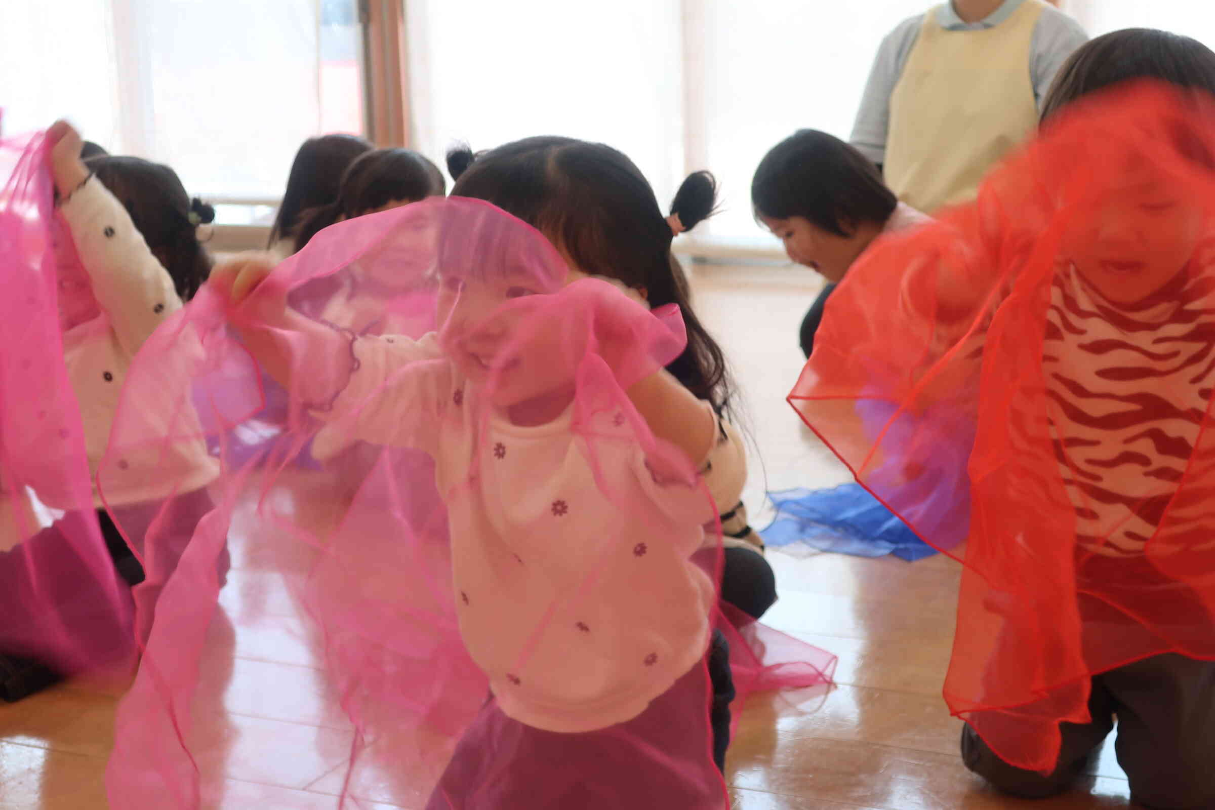 リトミックでは、音に合わせてオーガンジーを。　新たんぽぽ2組（2歳児）