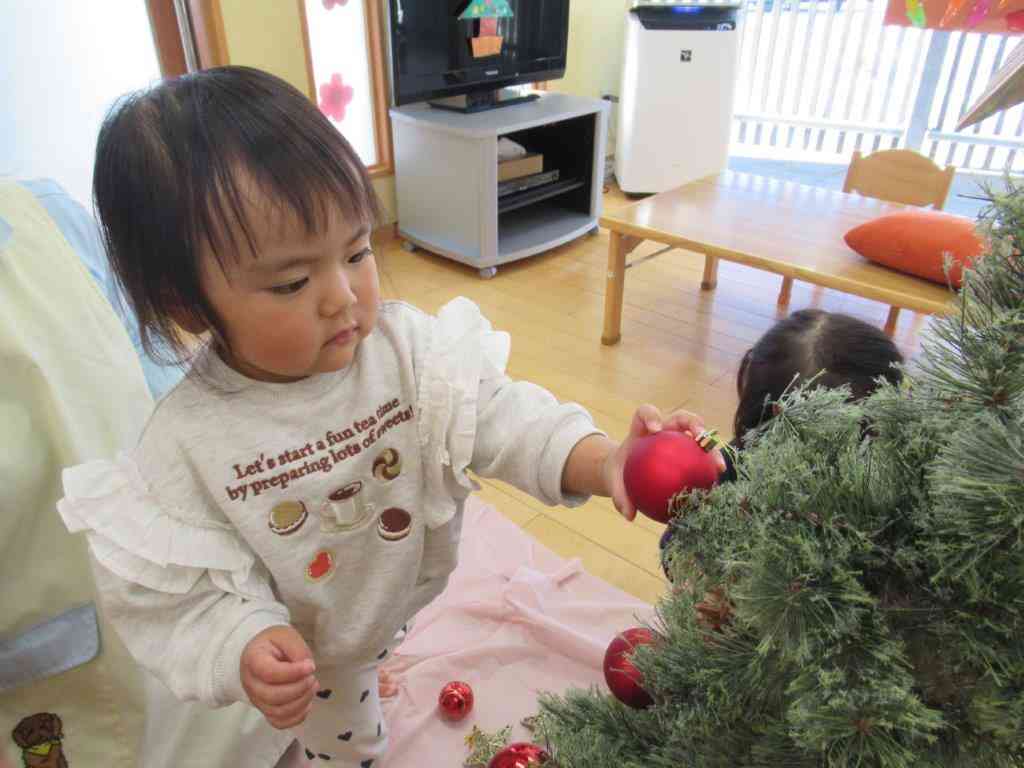 「赤がいい」と選んで飾る１歳児さん。