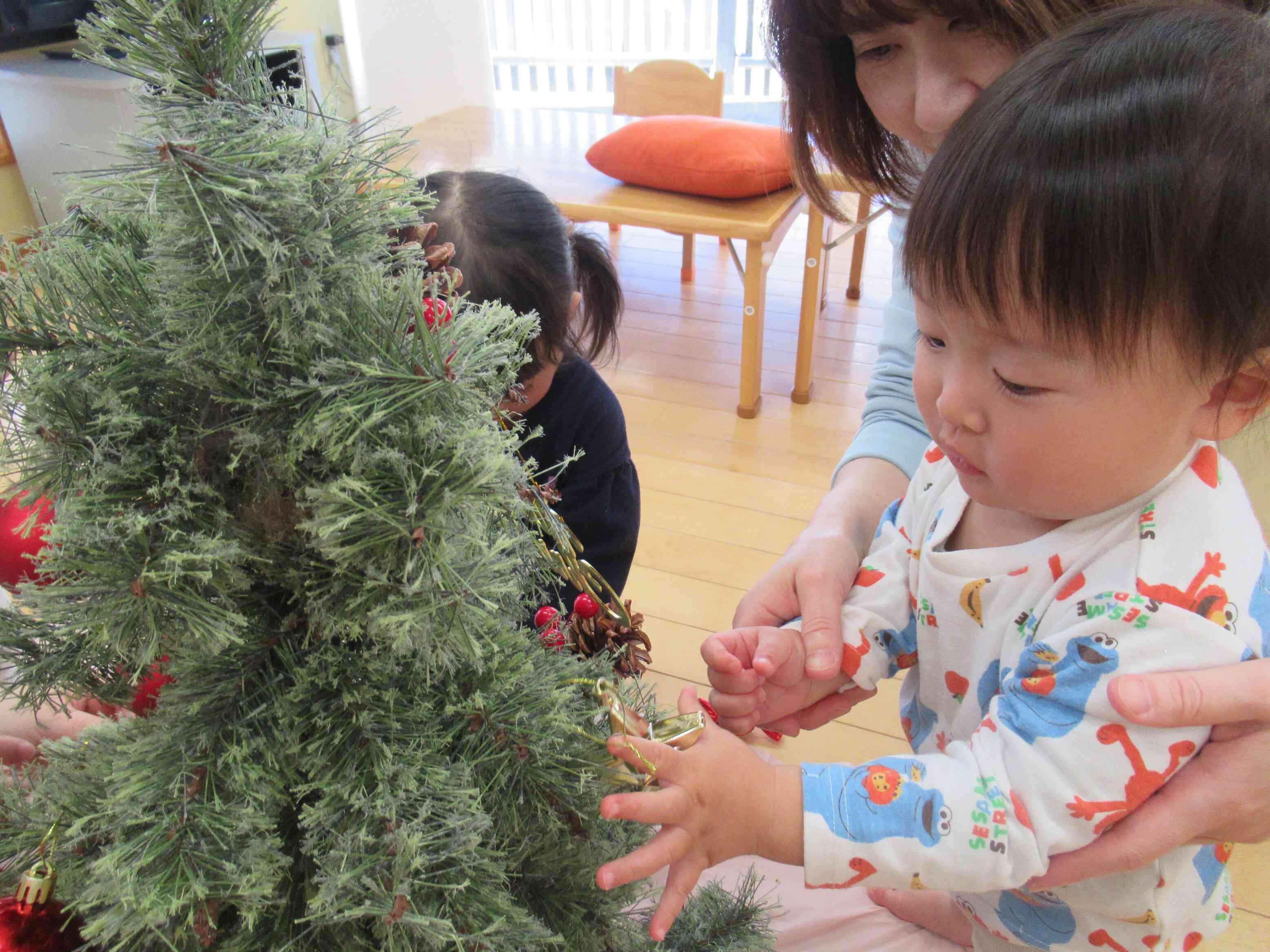 ０歳児さんも、先生といっしょに飾ってみました。