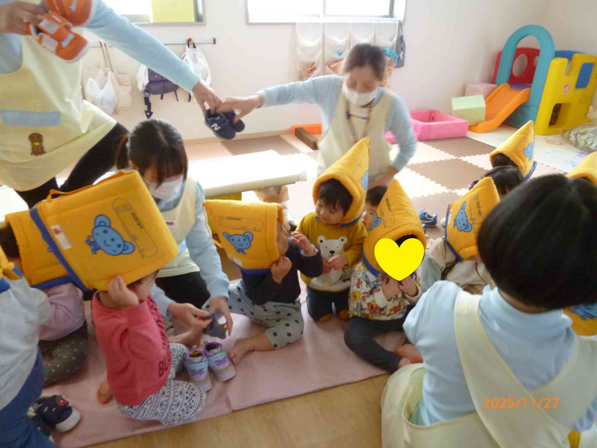 落下物があることを想定して段ボールパーティションの上で靴を履きますよ！防災頭巾もしっかり被れているね。