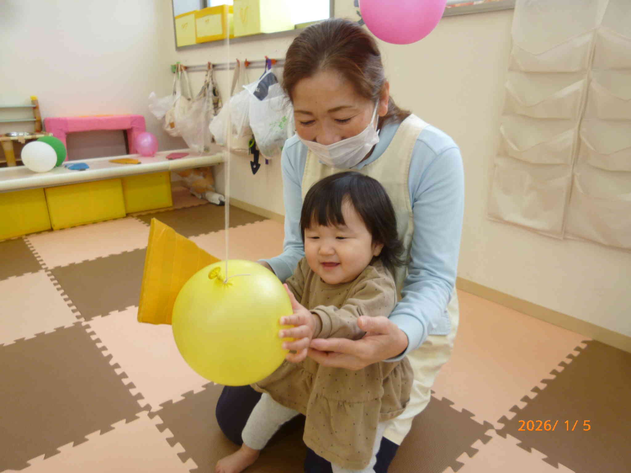 ひよこ組さんも羽根つきに挑戦しました。でもなかなか風船がつかまらなくて...あっ、逃げちゃう。先生と一緒に風船を捕まえると...この笑顔♡嬉しいね。ぎゅっぎゅって風船の感触を楽しみました♪