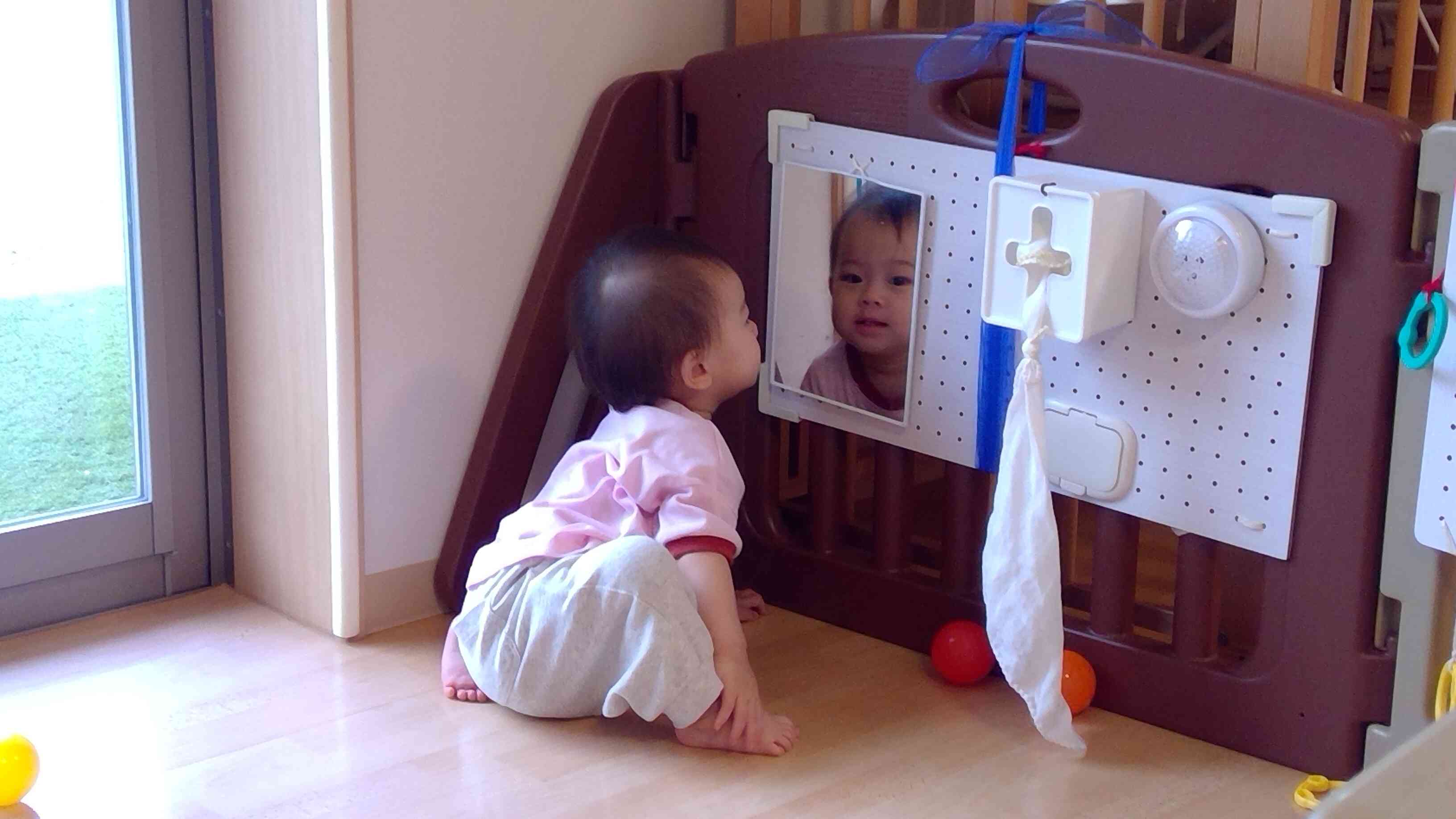 鏡に映るお顔に興味津々。表情を変えたり、先生の顔を見て楽しんでいます。