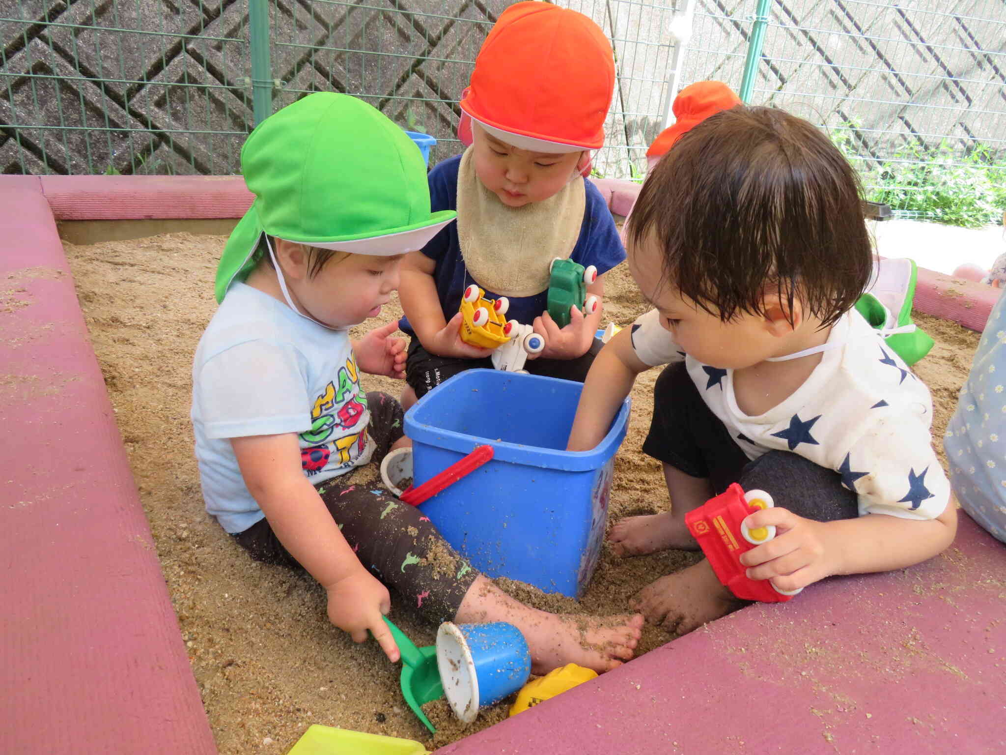 バケツを囲んで異年齢の子どもたちが仲良く遊びます
