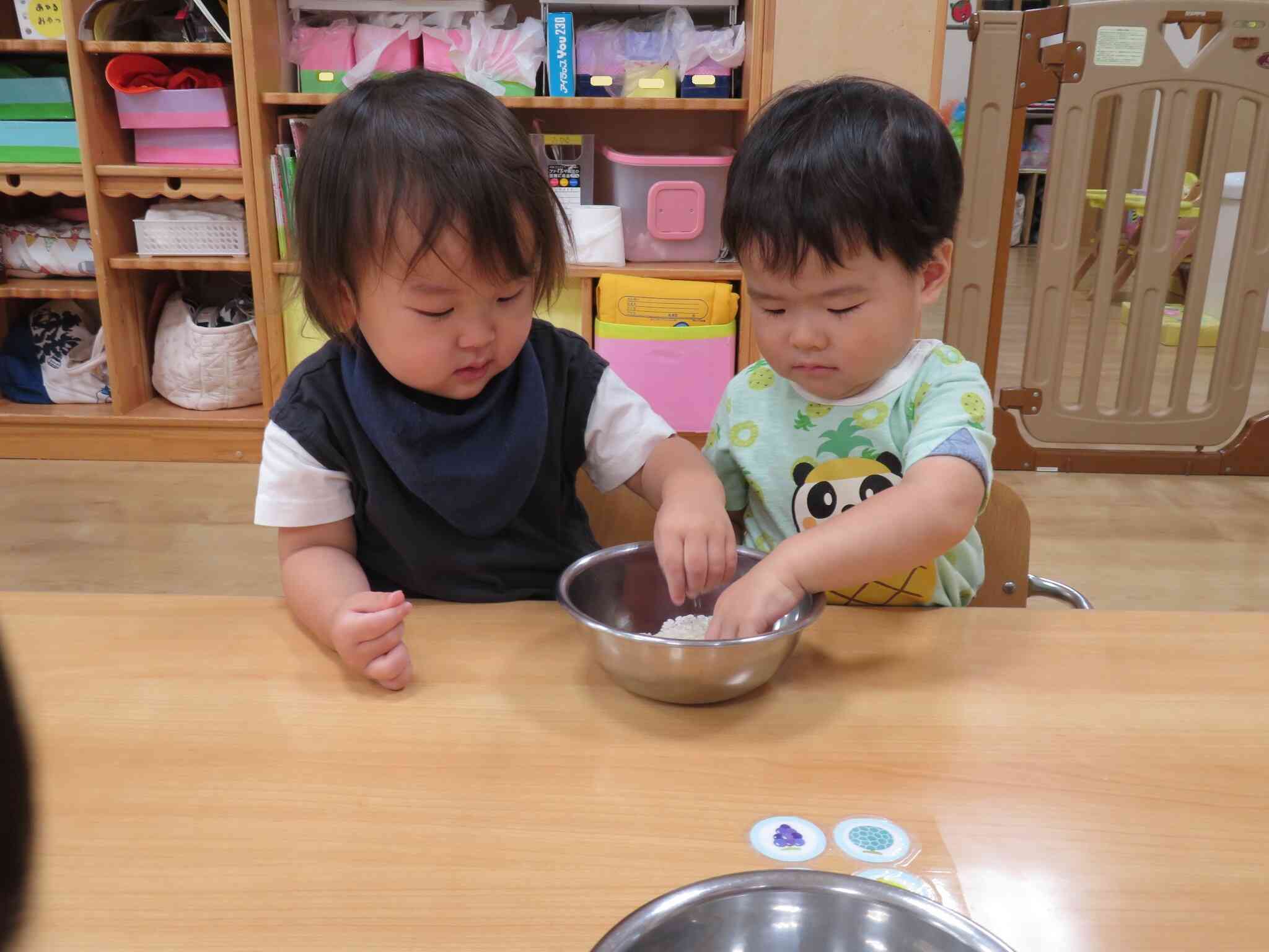 お米の感触を確かめる1歳児さん。