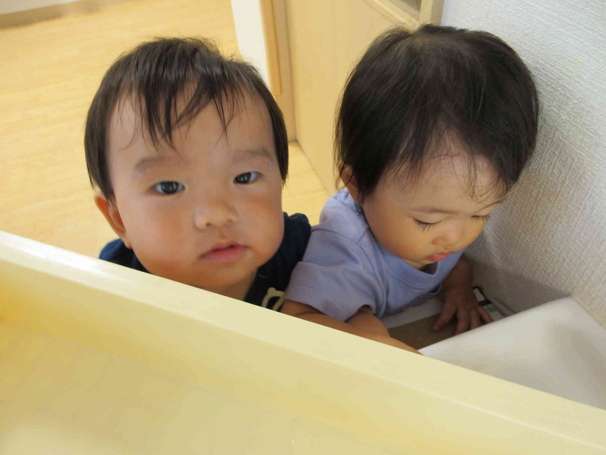 「お水遊びするの～？」保育者たちが水遊びの準備をしていると集まってきました。