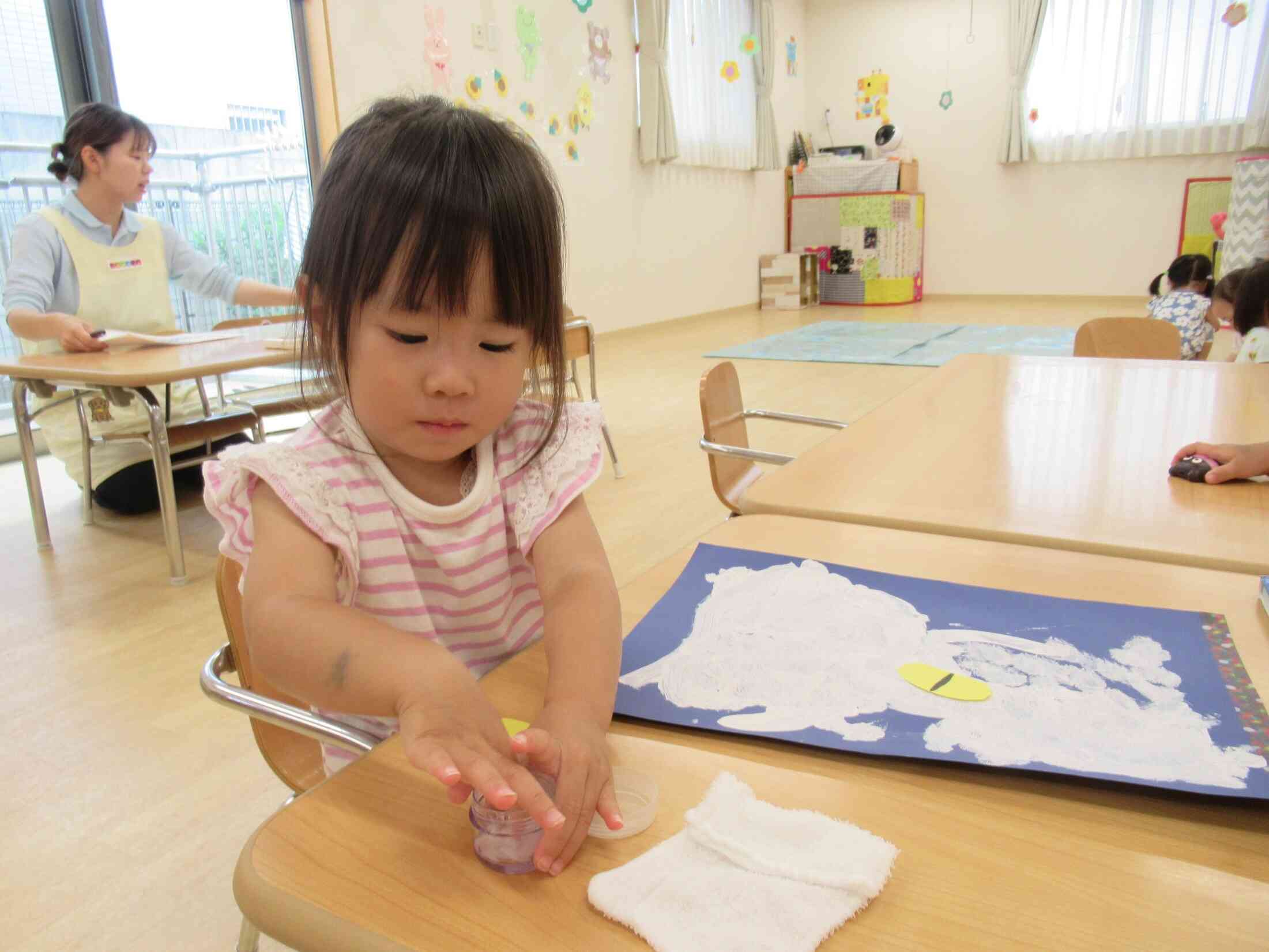 自分でできるよ!指先にそっとのりをつけます。動かないよう容器をしっかり押さえていてびっくり!