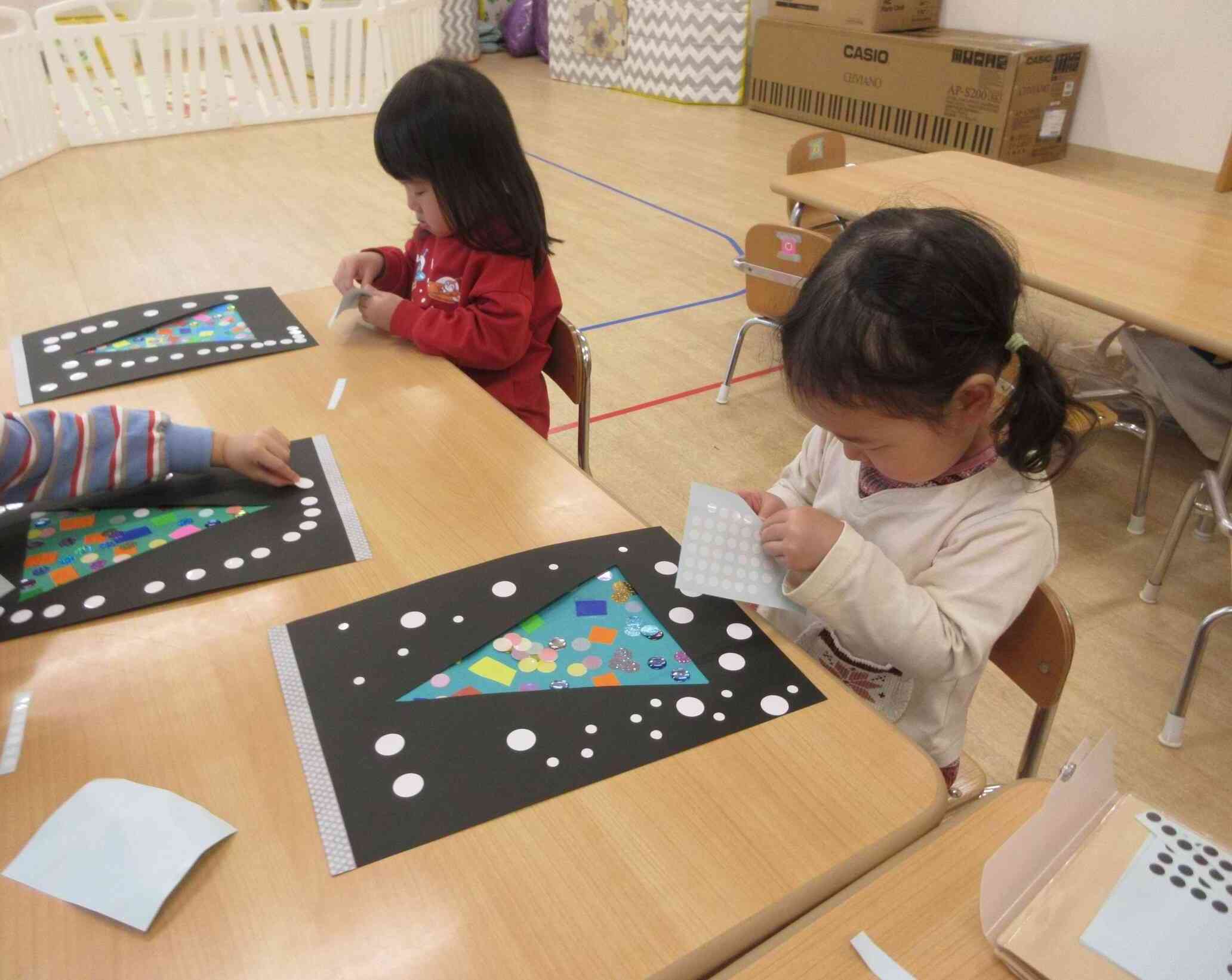 雪をイメージして画用紙いっぱいにシールを散りばめているよ♪