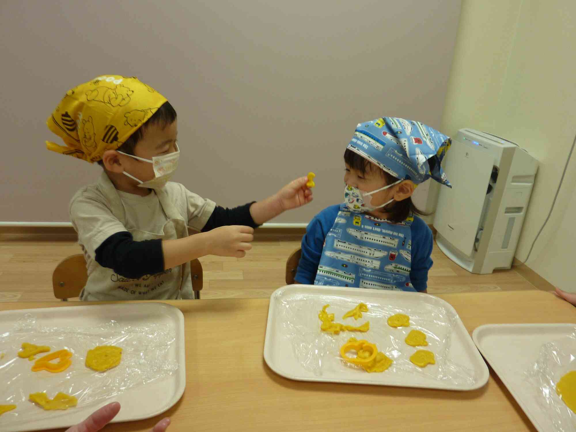 ２歳児クラスになるとエプロン・三角巾・マスクをしてハロウィンクッキー作りに挑戦