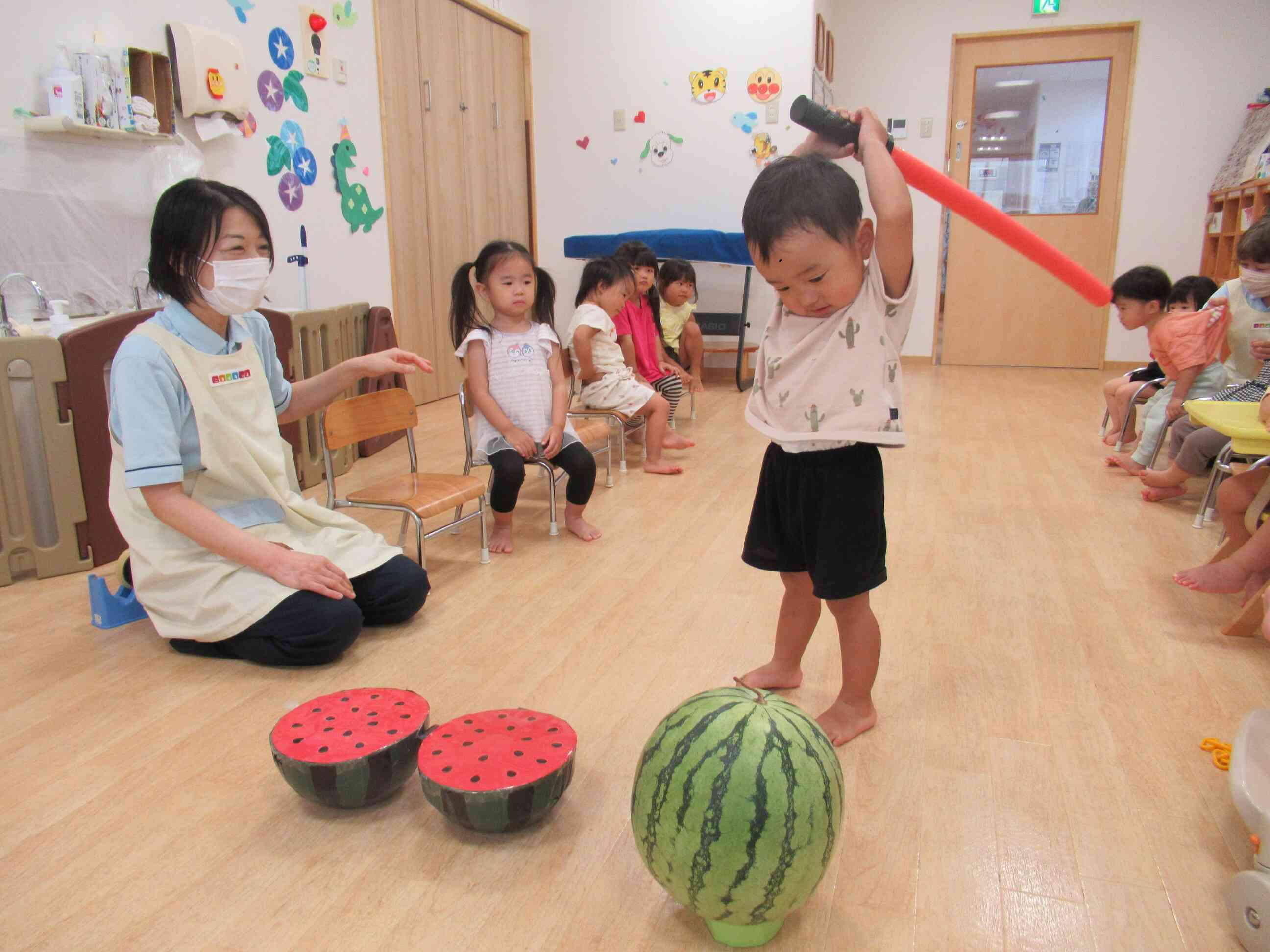 ２歳児クラスのお友達は、勢いをつけて割ります。