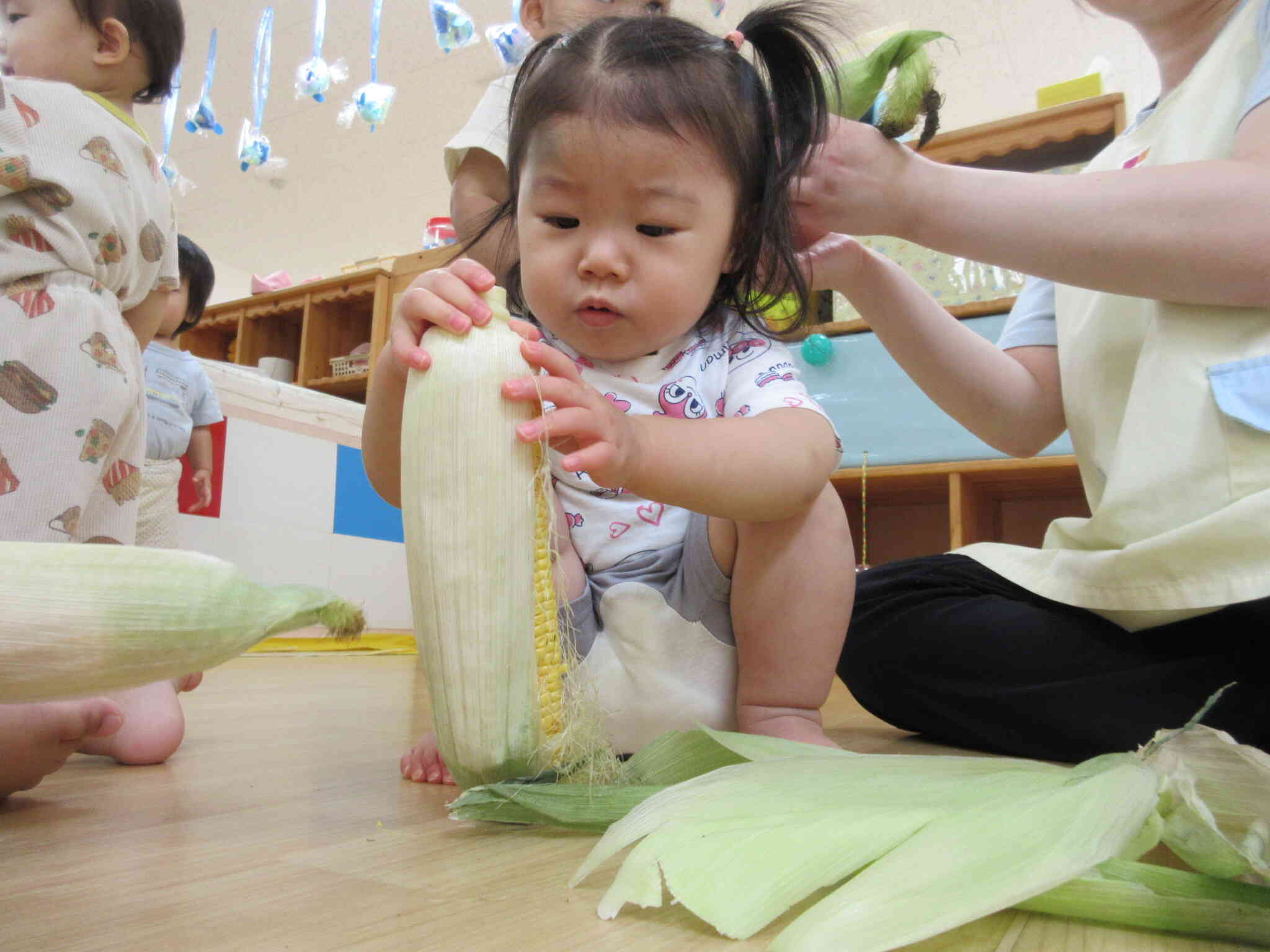 とうもろこしの皮むきに挑戦！（1歳児・食育）