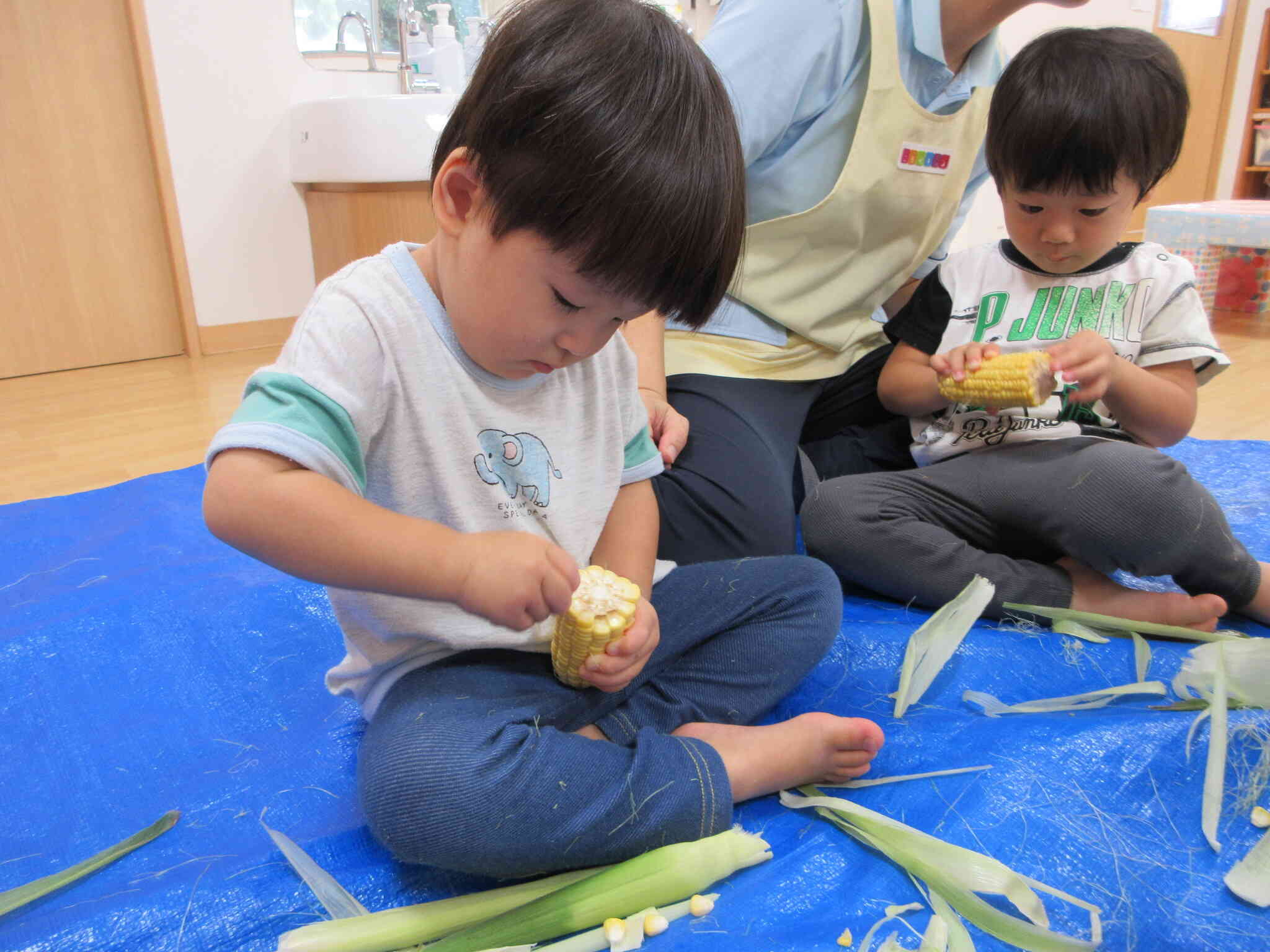 とうもろこしの皮むき（8月食育・２歳児）
