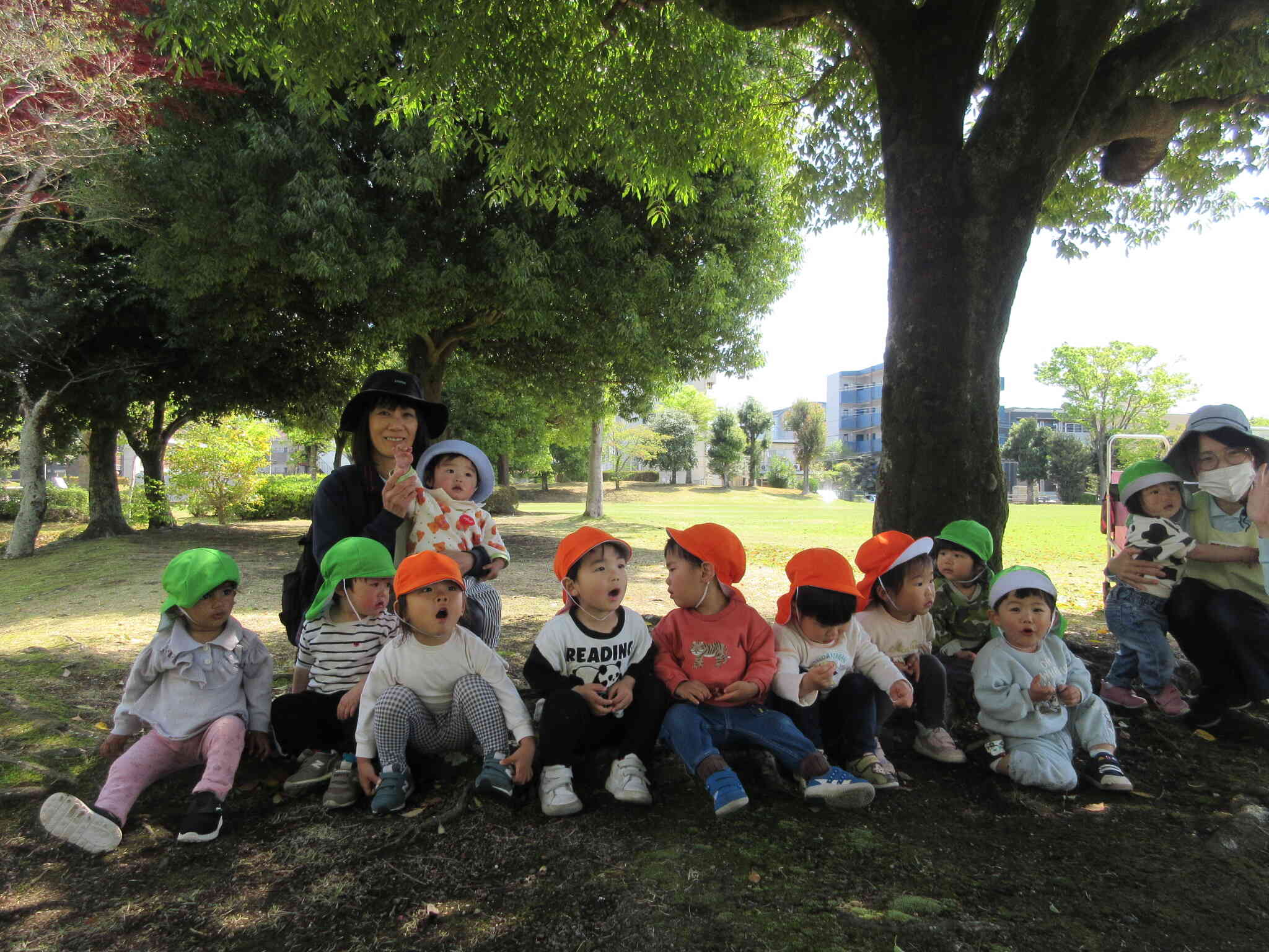 大きな木の木陰で根っこを椅子代わりに「お茶タイム」　公園は広くて走れて、発見がいっぱいでみんなの最高の遊び場です！
