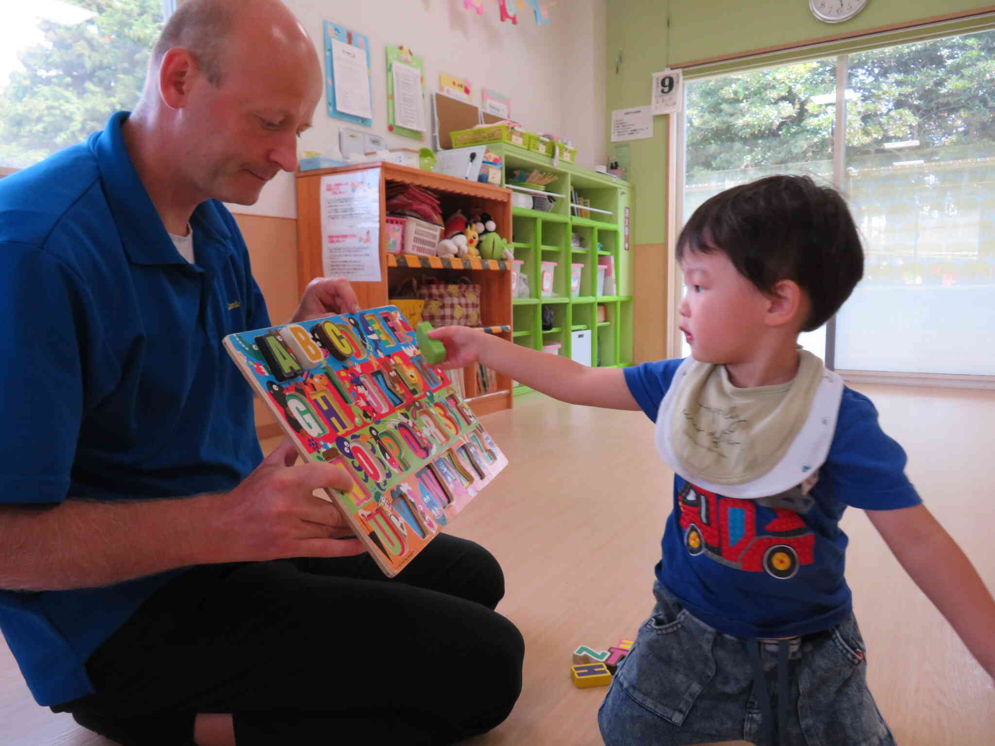 2歳児さんの英語教室。イアン先生に言われたアルファベットをはめます。