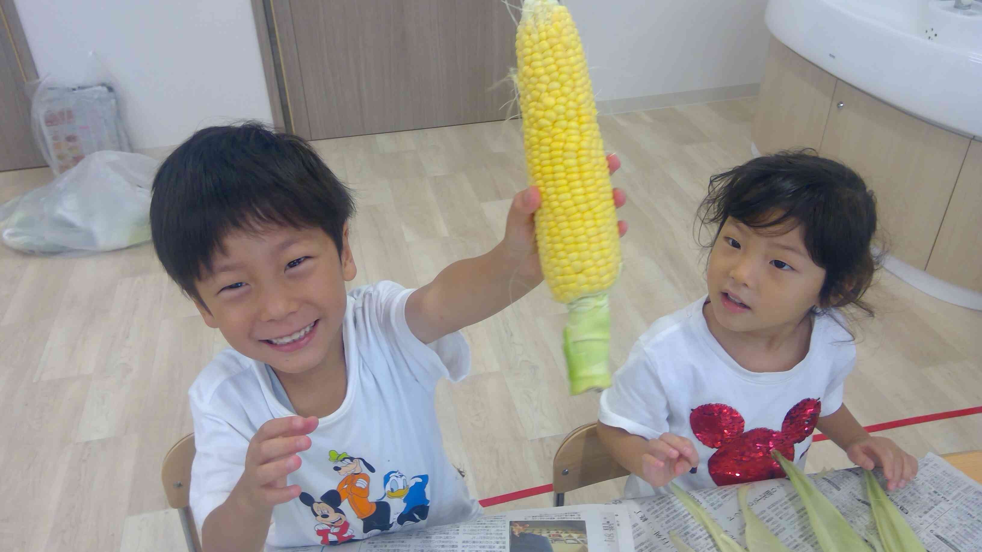 7月の食育～幼児クラスとうもろこしの皮むき～