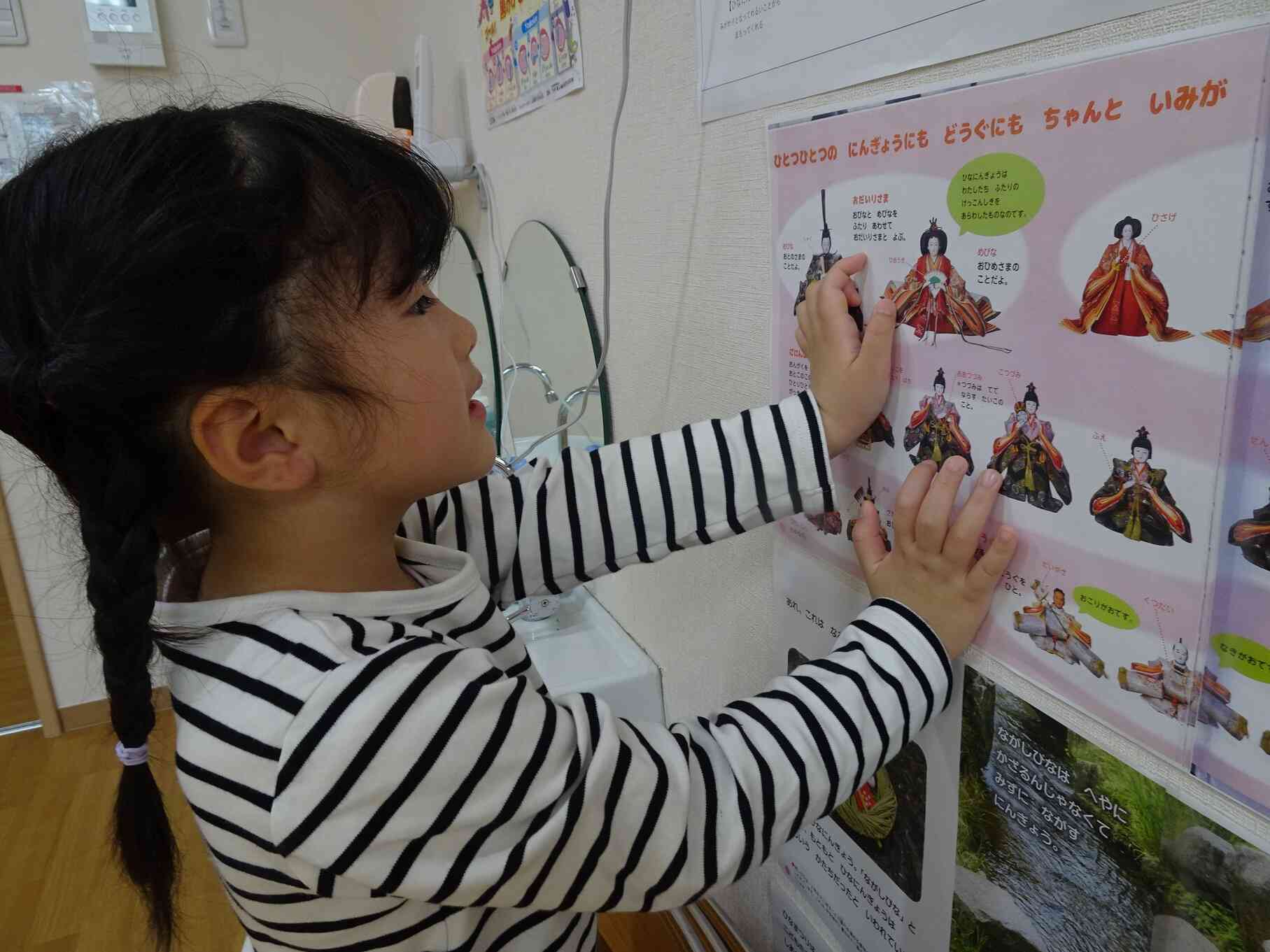 「これがおひなさまで～・・・これは三人官女で～・・・」と表をみてお勉強中！