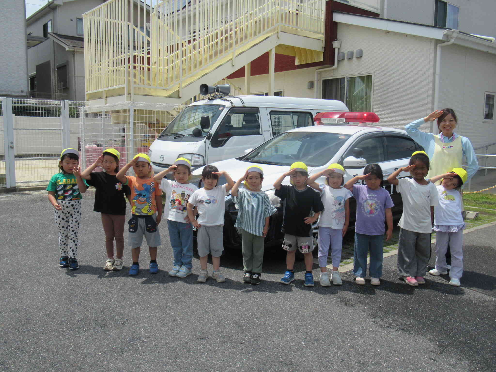 きりんぐみ（5歳児）パトカーと一緒に記念撮影です。敬礼姿がかっこいいね！