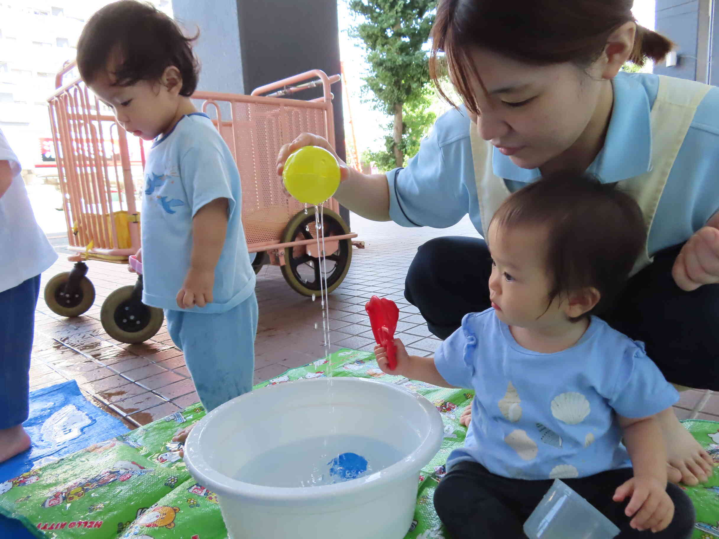 0歳児さんも、先生と一緒に水あそびに参加です♪