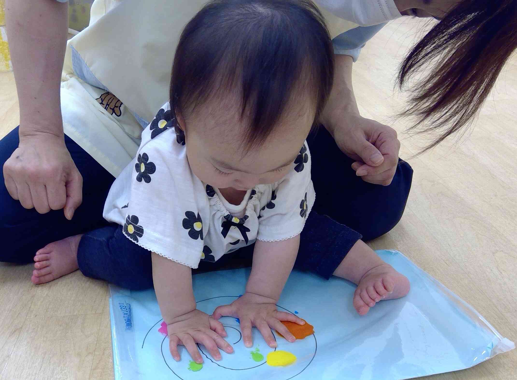 両手で「えいっ！」絵の具の感触を楽しみました。