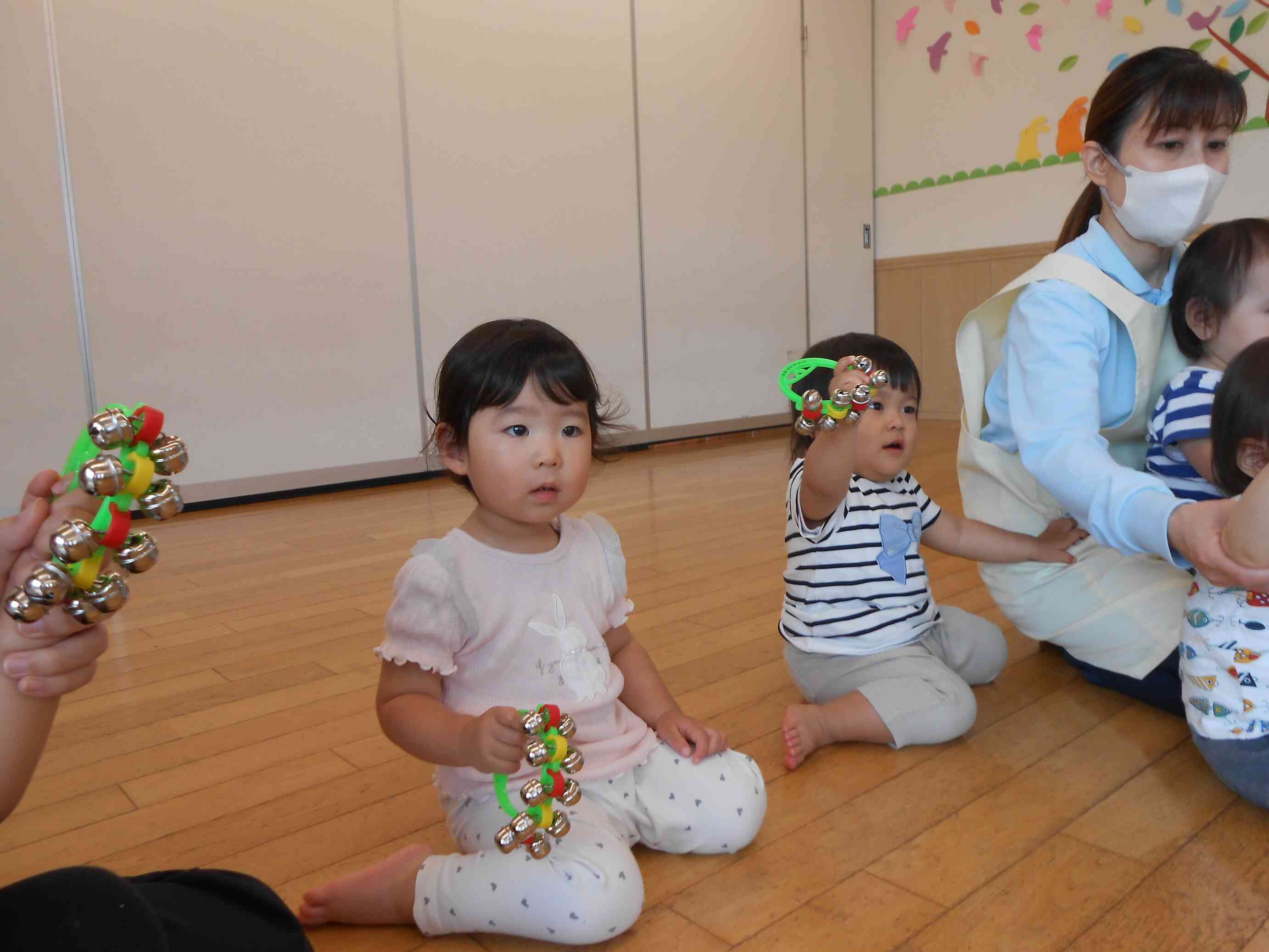 リトミックの先生を見ながら、鈴を鳴らすタイミングを計っています