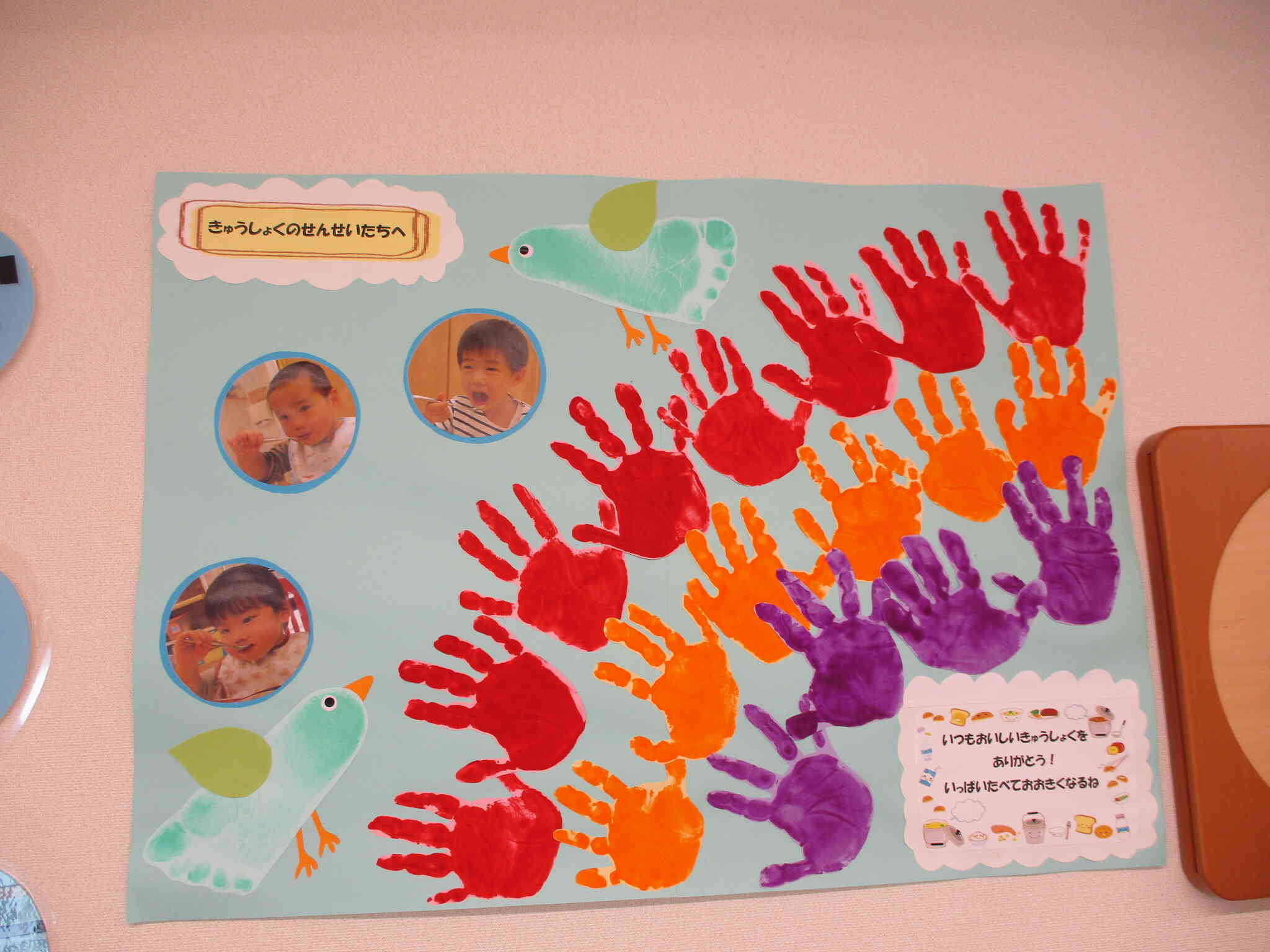手形は虹に、足形は鳥に変身しました！周りには大きく口を開けてご飯を食べている写真も貼りました！