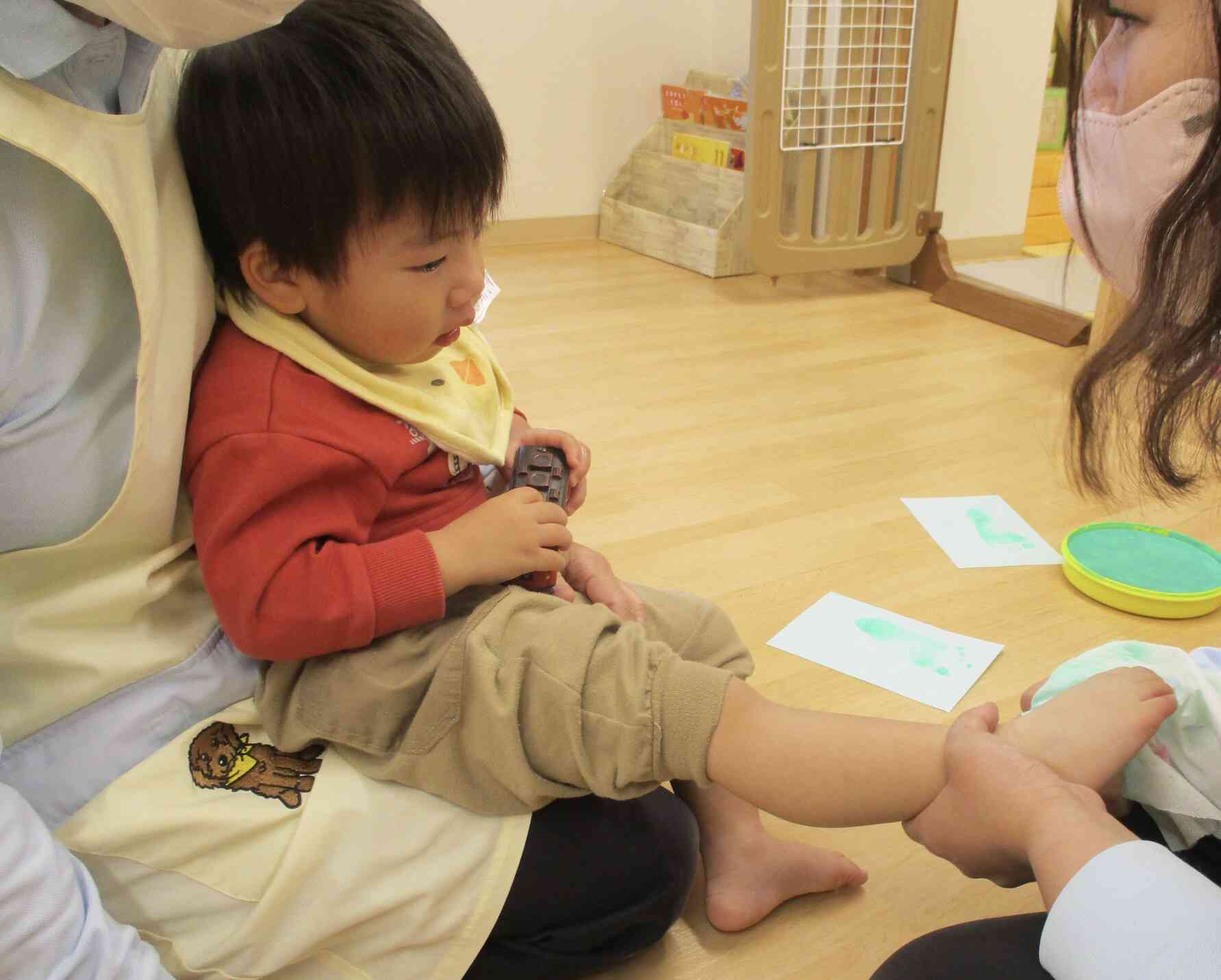 こちらのお友だちは手に絵の具をつけるとびっくり！な様子だったので、代わりに足形を取りました。手形と足形、何に変身したかというと…