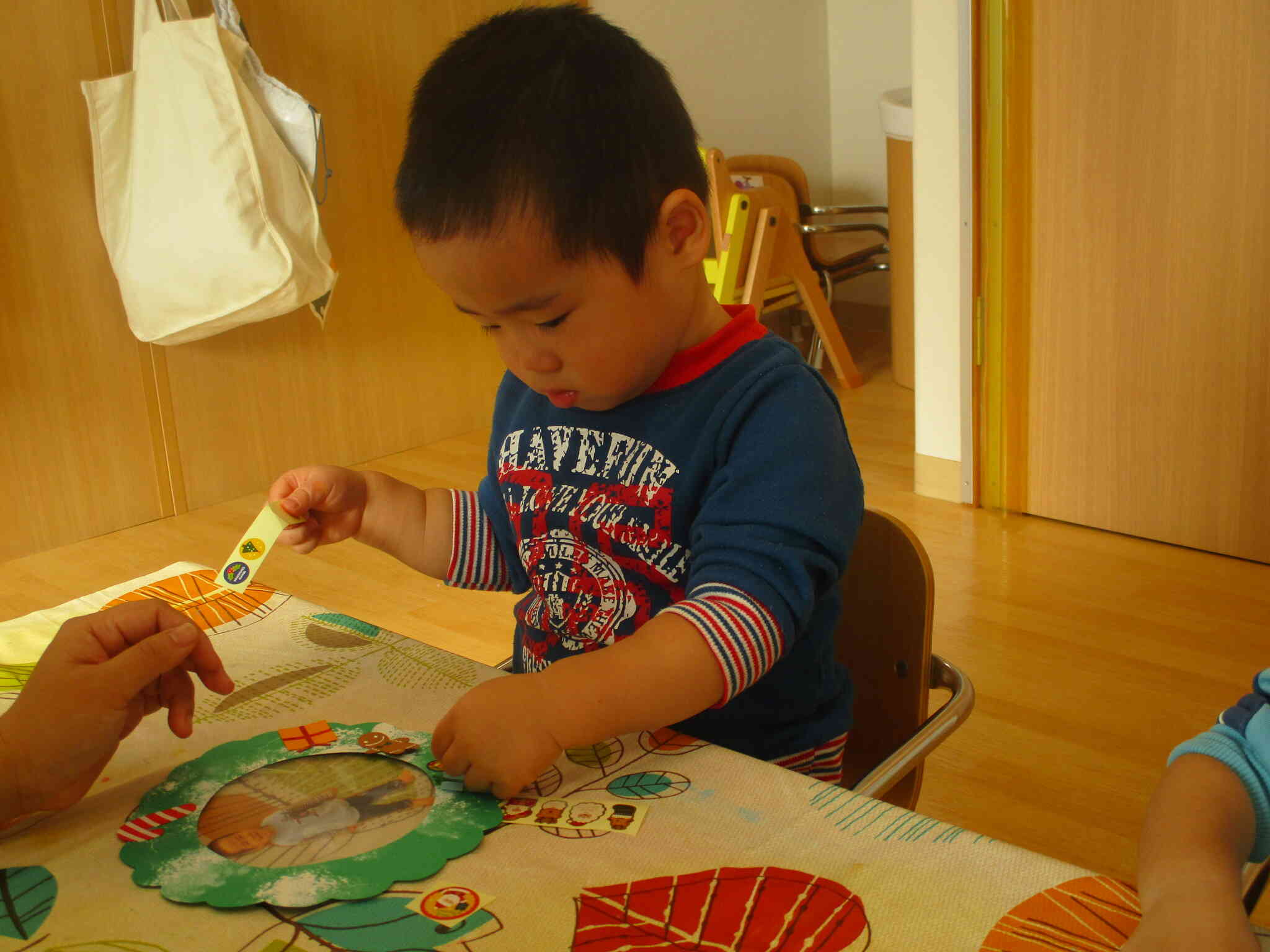 のりでパーツを貼った後は、大好きなシール貼りをしました!自分で台紙からシールをはがして貼ることができていました。