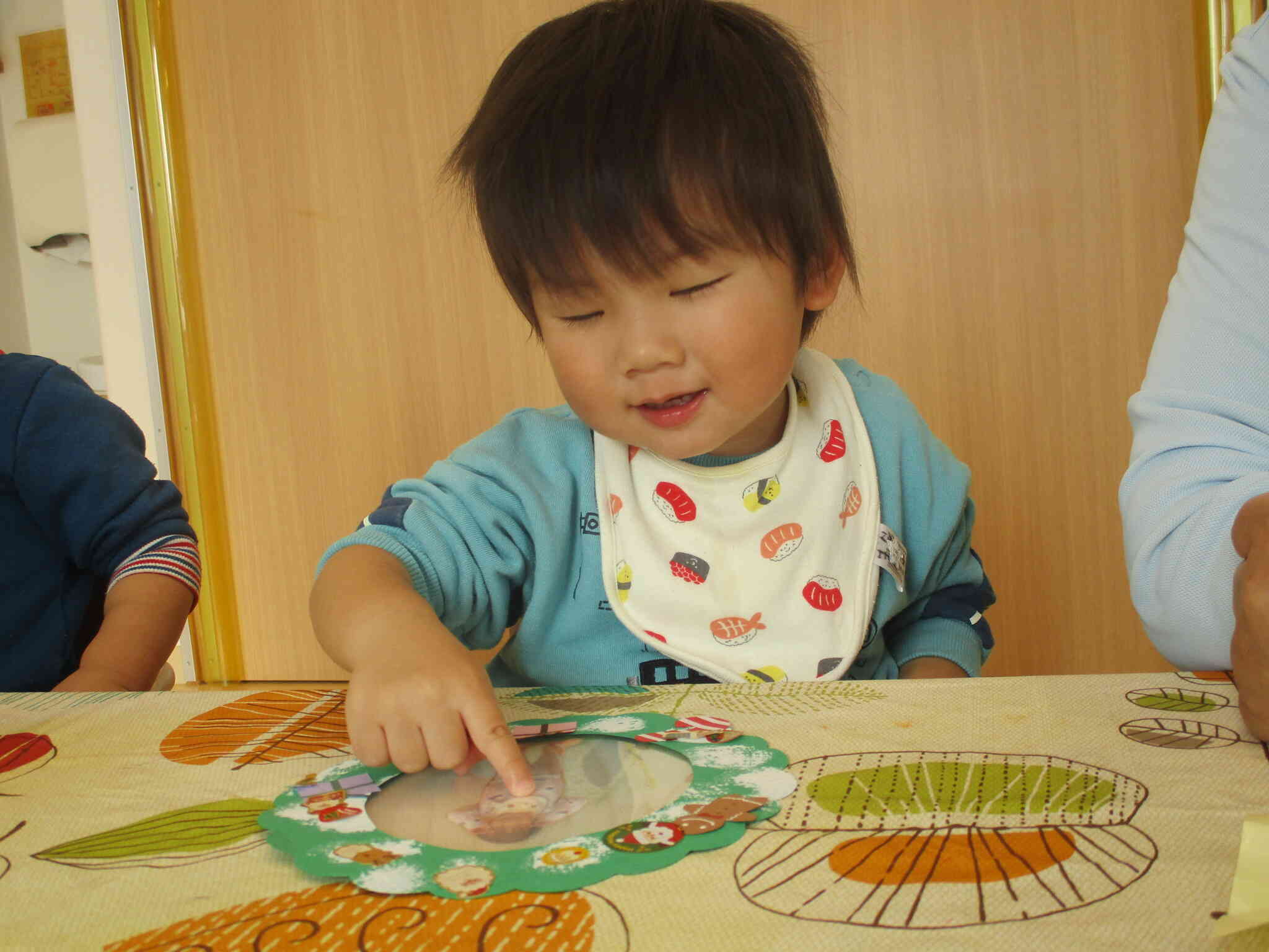 写真を撮ってリースの真ん中に入れました。自分の顔が見えるのが楽しかったようで、何度も触っていました。