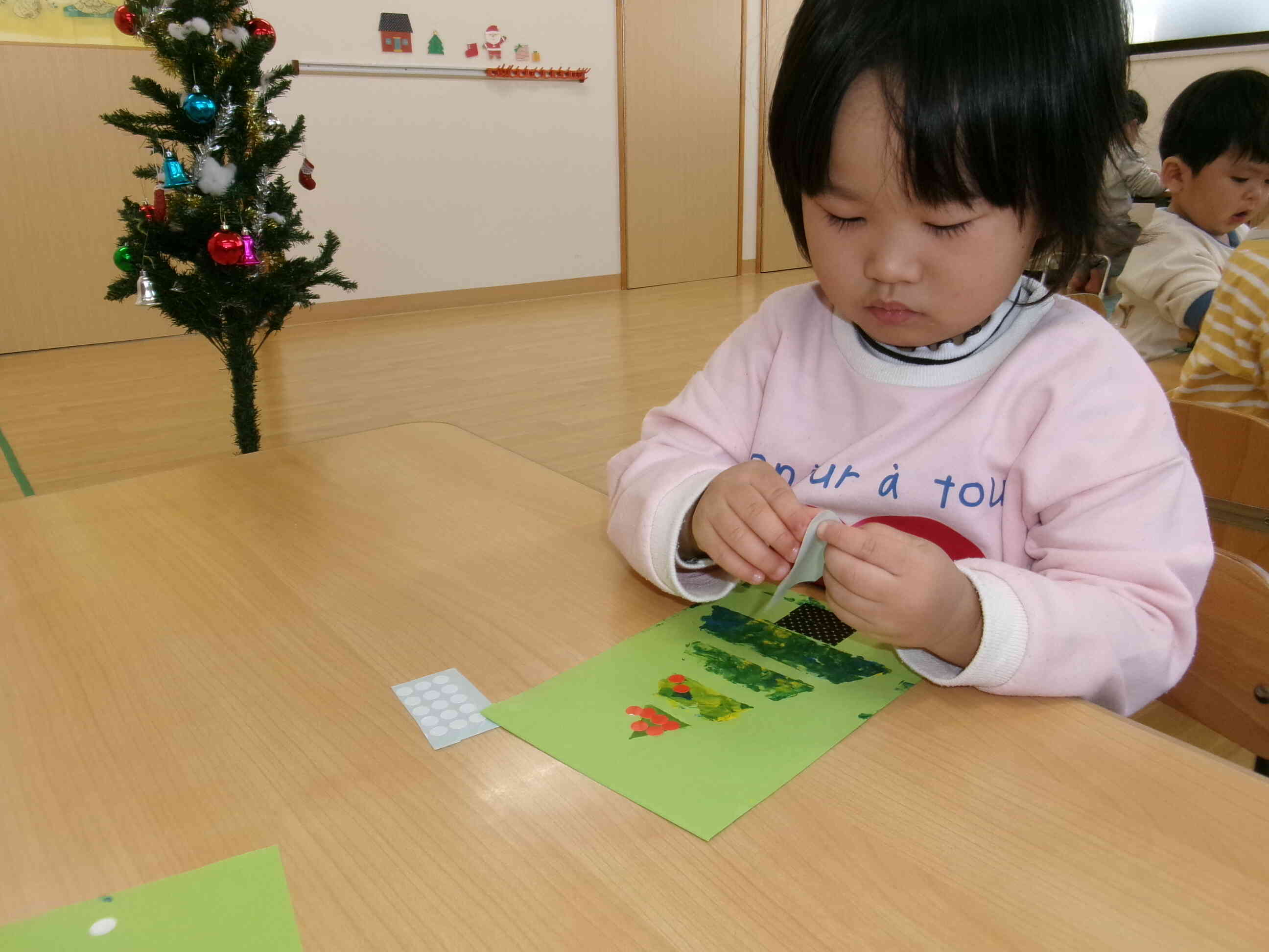 私は赤い飾りを貼るね！