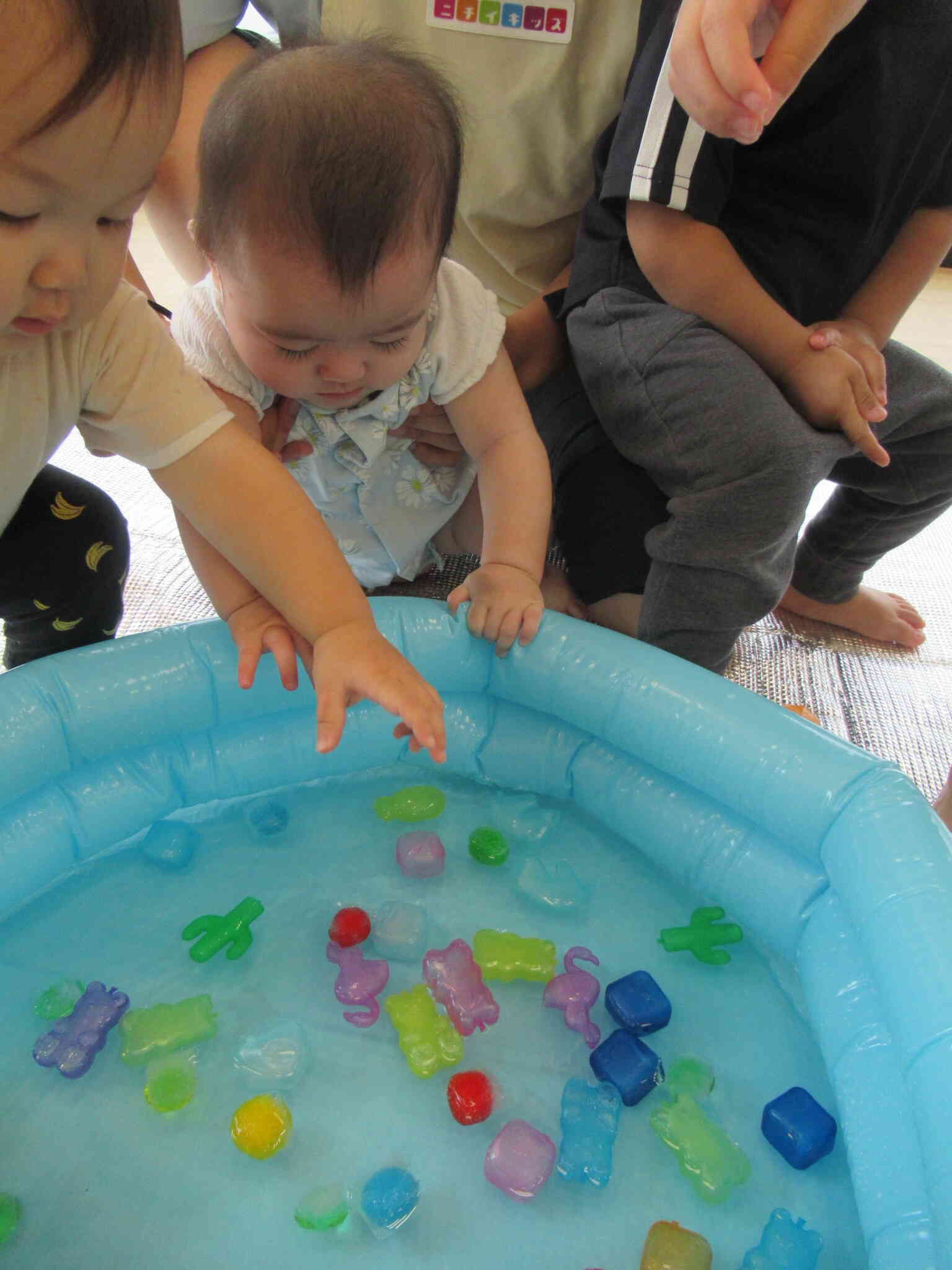 ０歳児さんも先生のお膝で…あそぼ