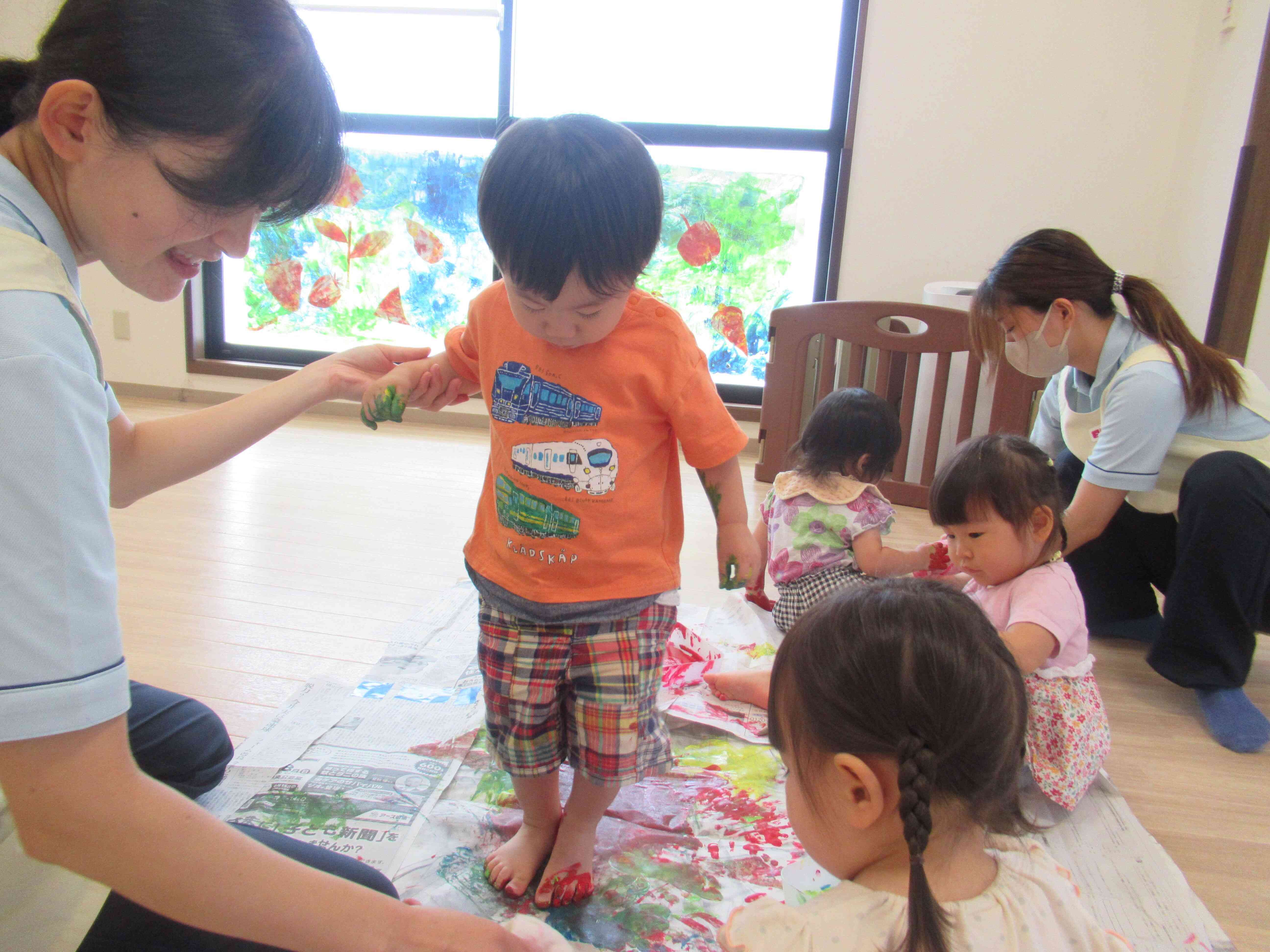 足に絵具をつけたお友達。紙の上で滑る感触が面白くて滑りながら色をつけました。