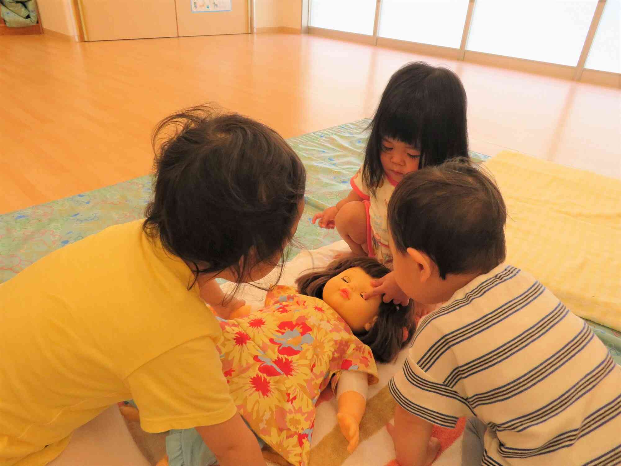 ベビーマッサージに使用する人形に興味津々な子どもたちです！