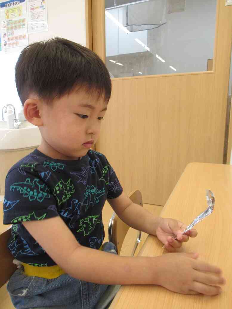 きりん組（５歳児）は折り紙でスプーンにも挑戦しました。完成したスプーンの折り紙を見ているお友だち。