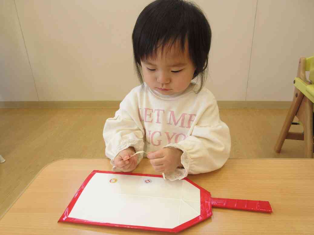 シールを貼って、自分だけの羽子板が完成しました♡(ひよこ組さん・0歳児)