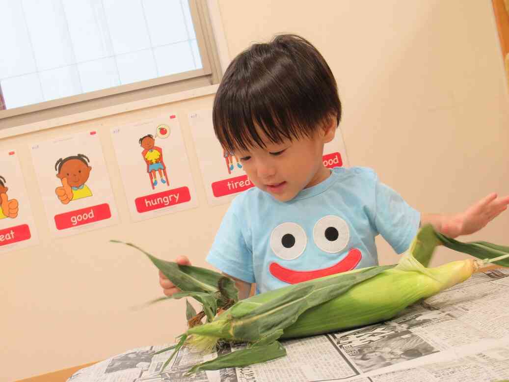 トウモロコシの皮むきをしました！（乳児クラス）