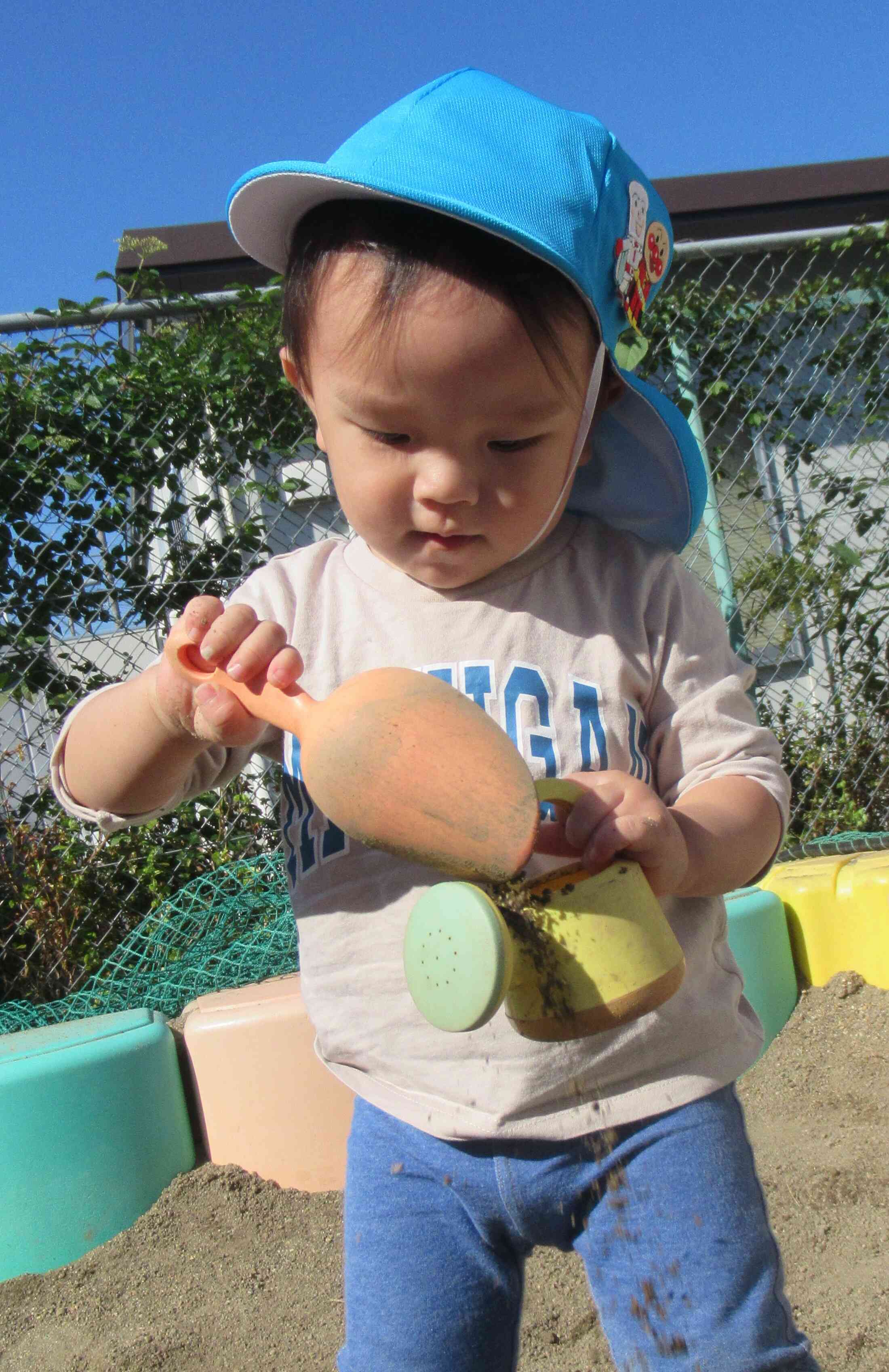小さいじょうろの中に砂を入れます。