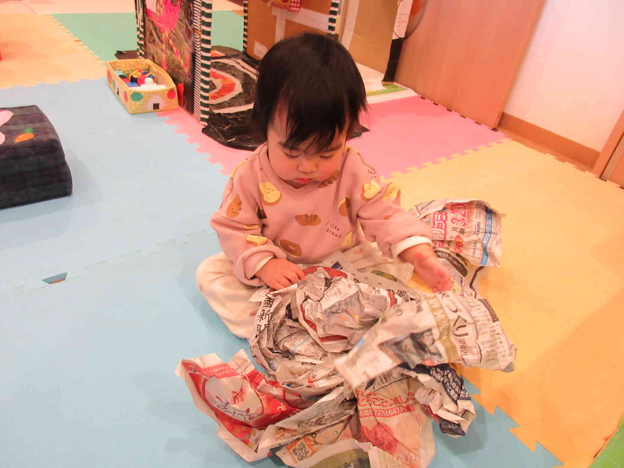 手形押し、気合い入れすぎて顔が手にくっきそうで全く誰か分からない(笑)　製作後の新聞紙あそびの写真です。
