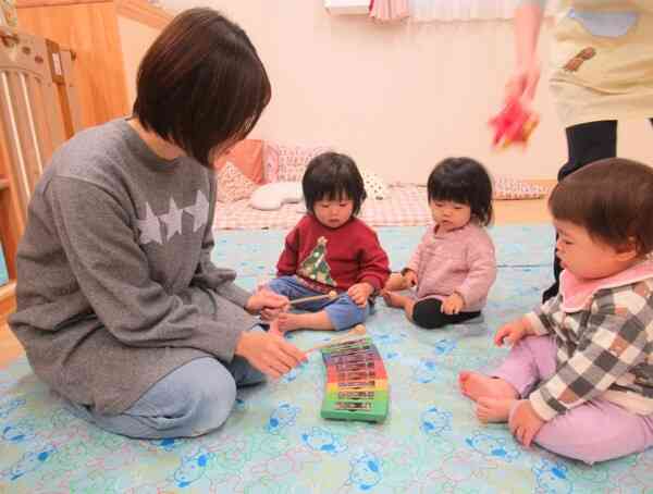 芸術士さんと0歳児さんがグロッケンを使って遊んでいるよ。清らかな音に集中している子ども達です。