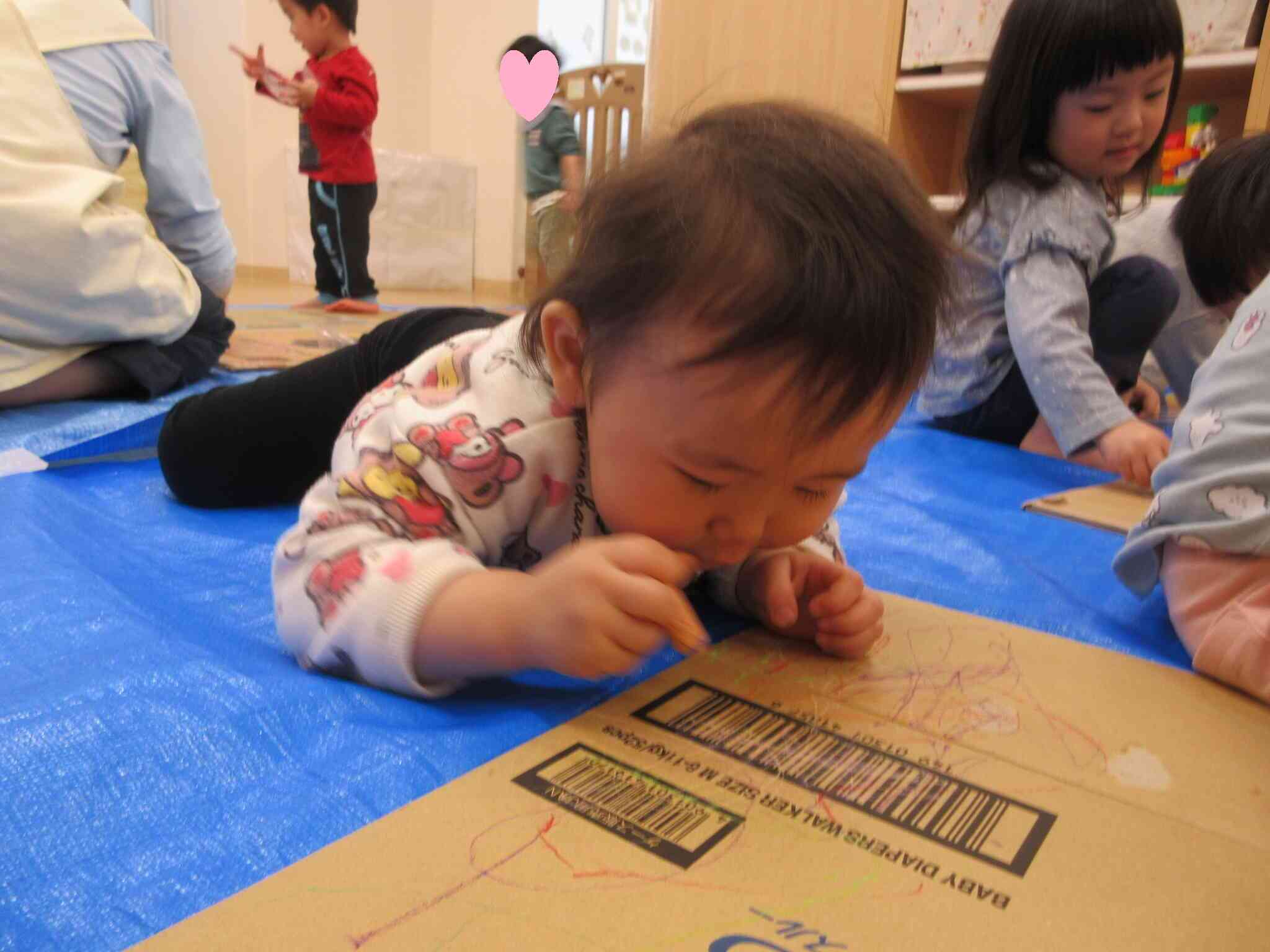 段ボールに一生懸命お絵描きをしていますね。