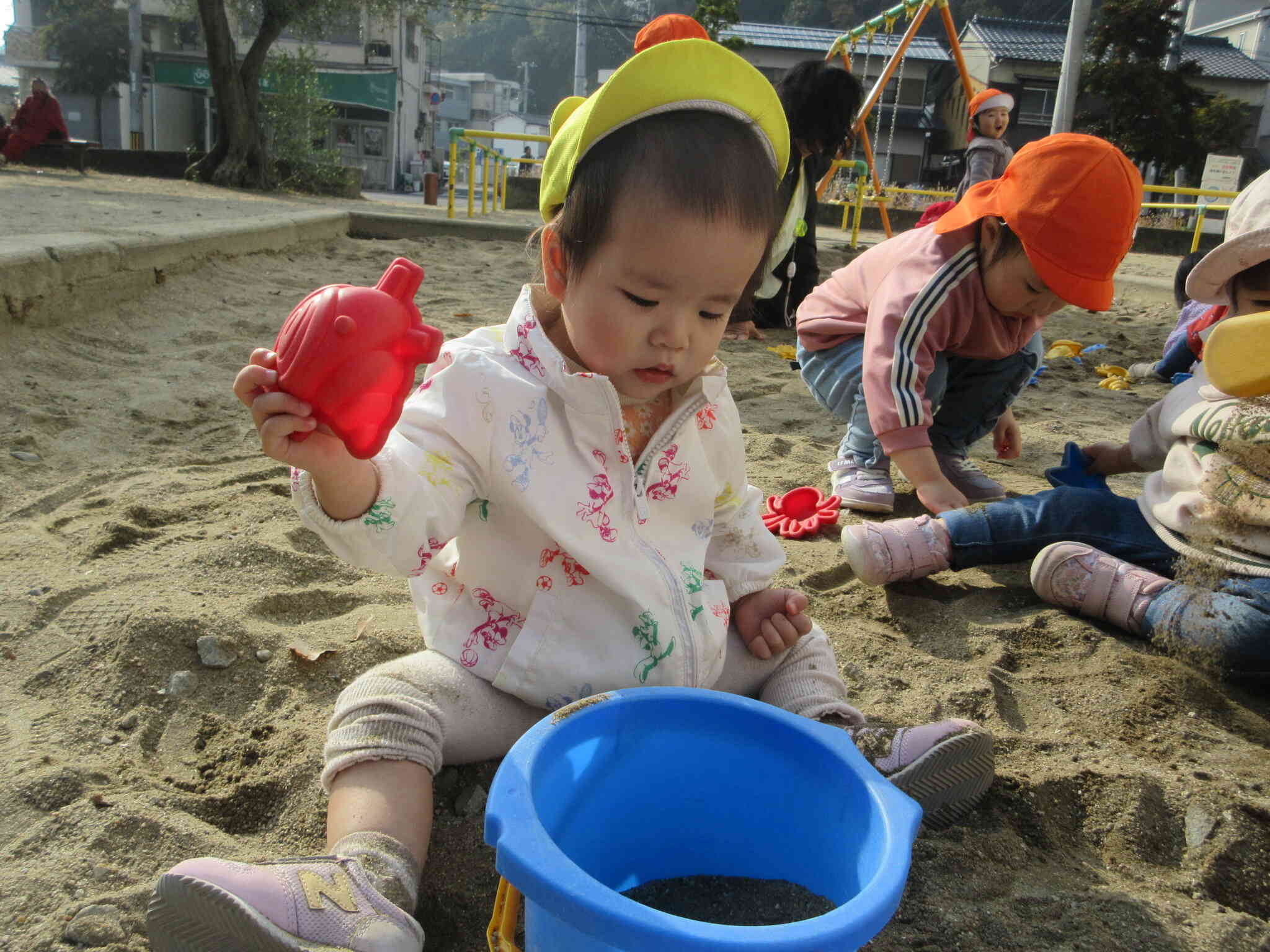 バケツに砂を集めることに夢中になっているお友だち！