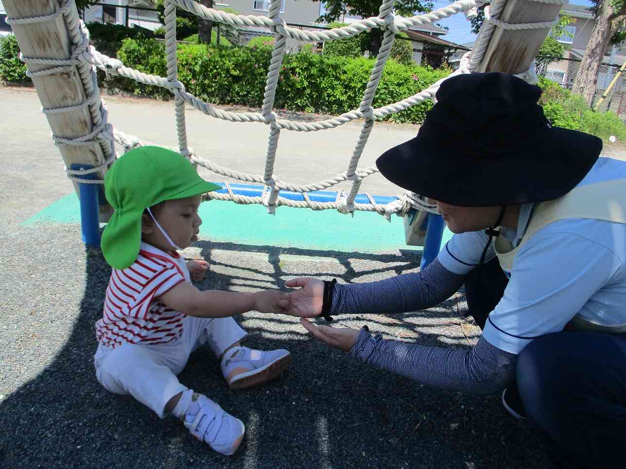 「はい、どうぞ」保育者と一緒に大好きな石拾いに夢中です♪