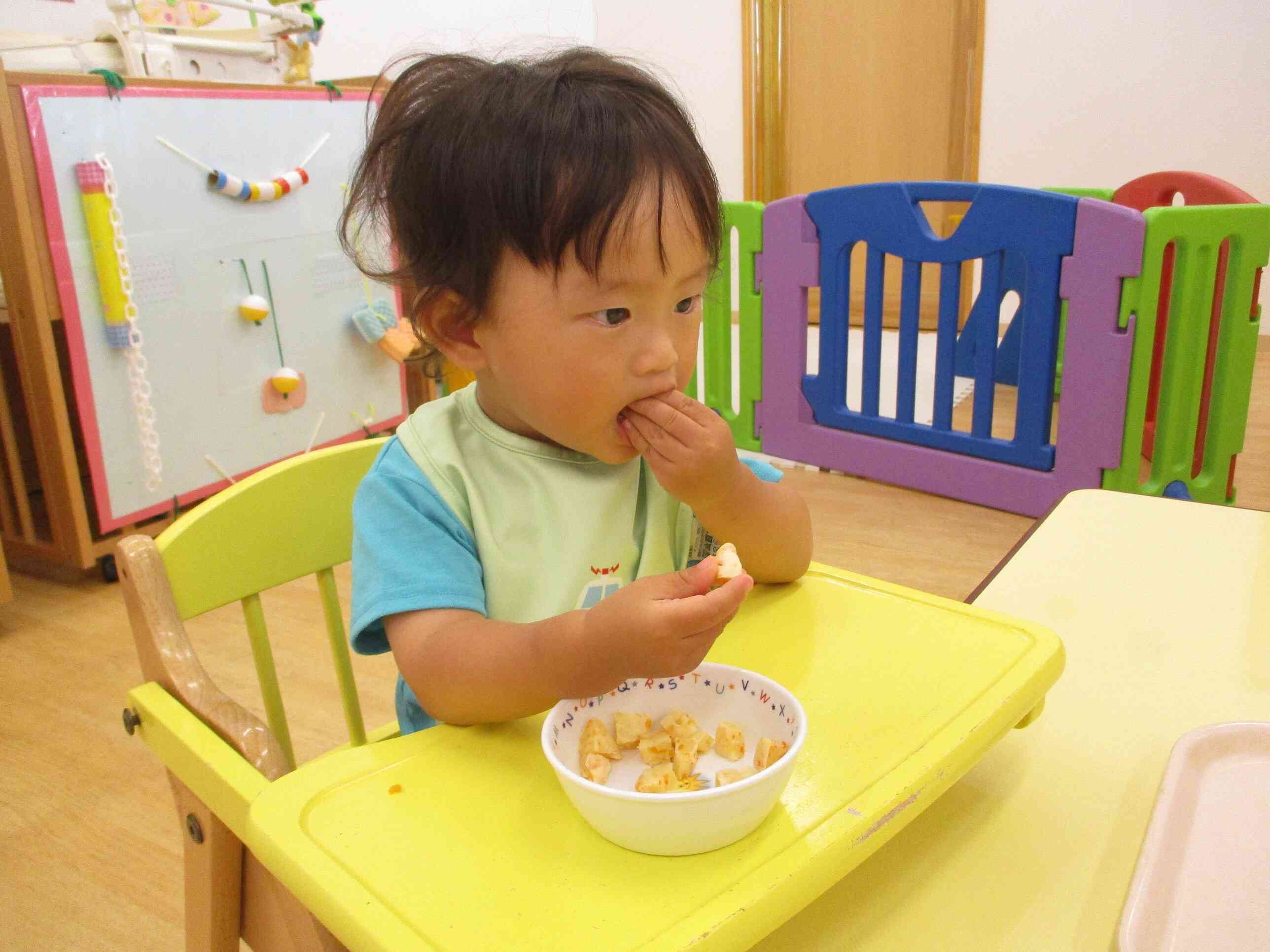 午後の手作りおやつの蒸しパンを、手で上手に食べていますね。もぐもぐ、おいしいね。