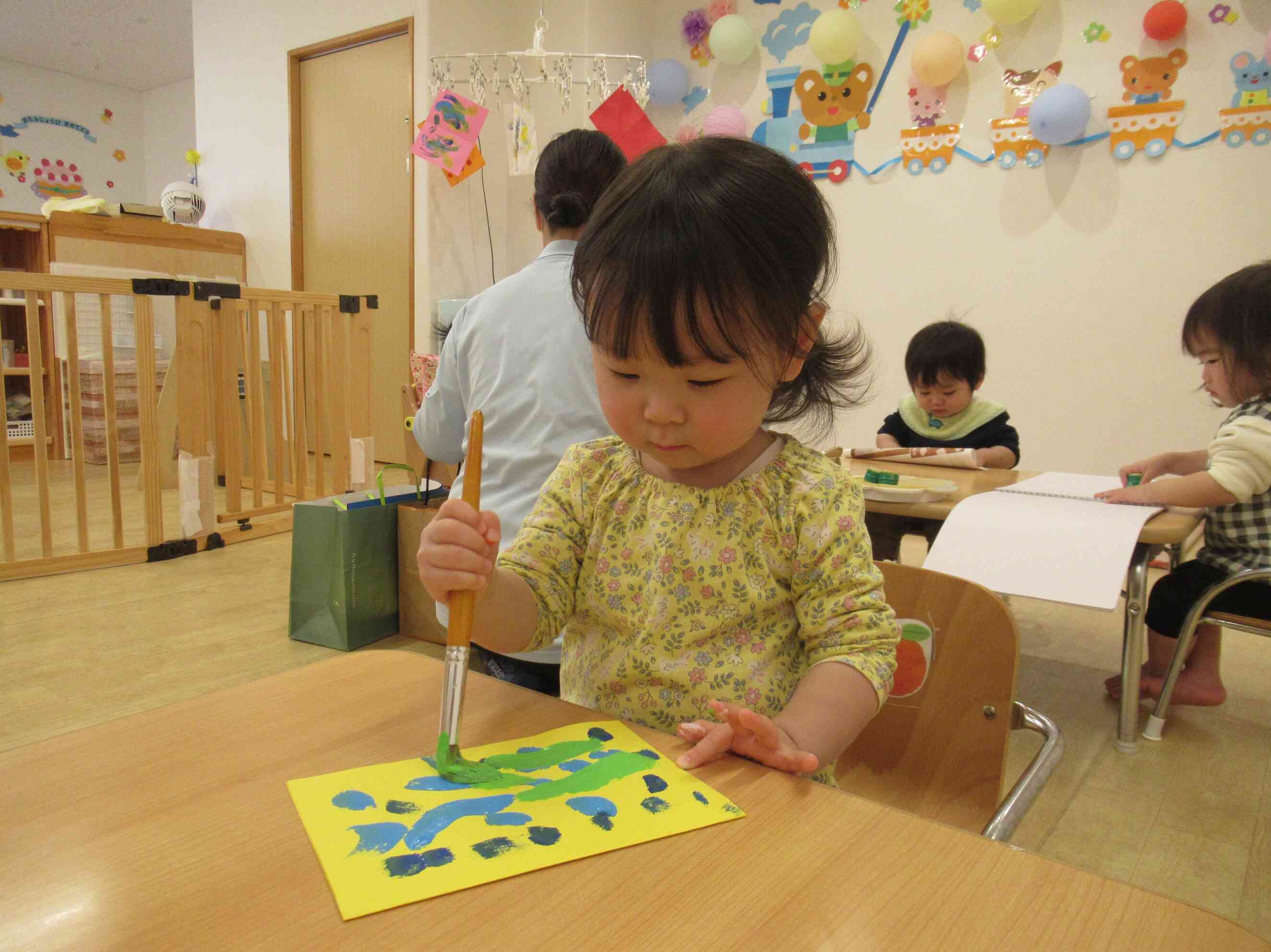 色を重ねていくうさぎ組（2歳児）のYちゃん。出来上がりが楽しみだね！