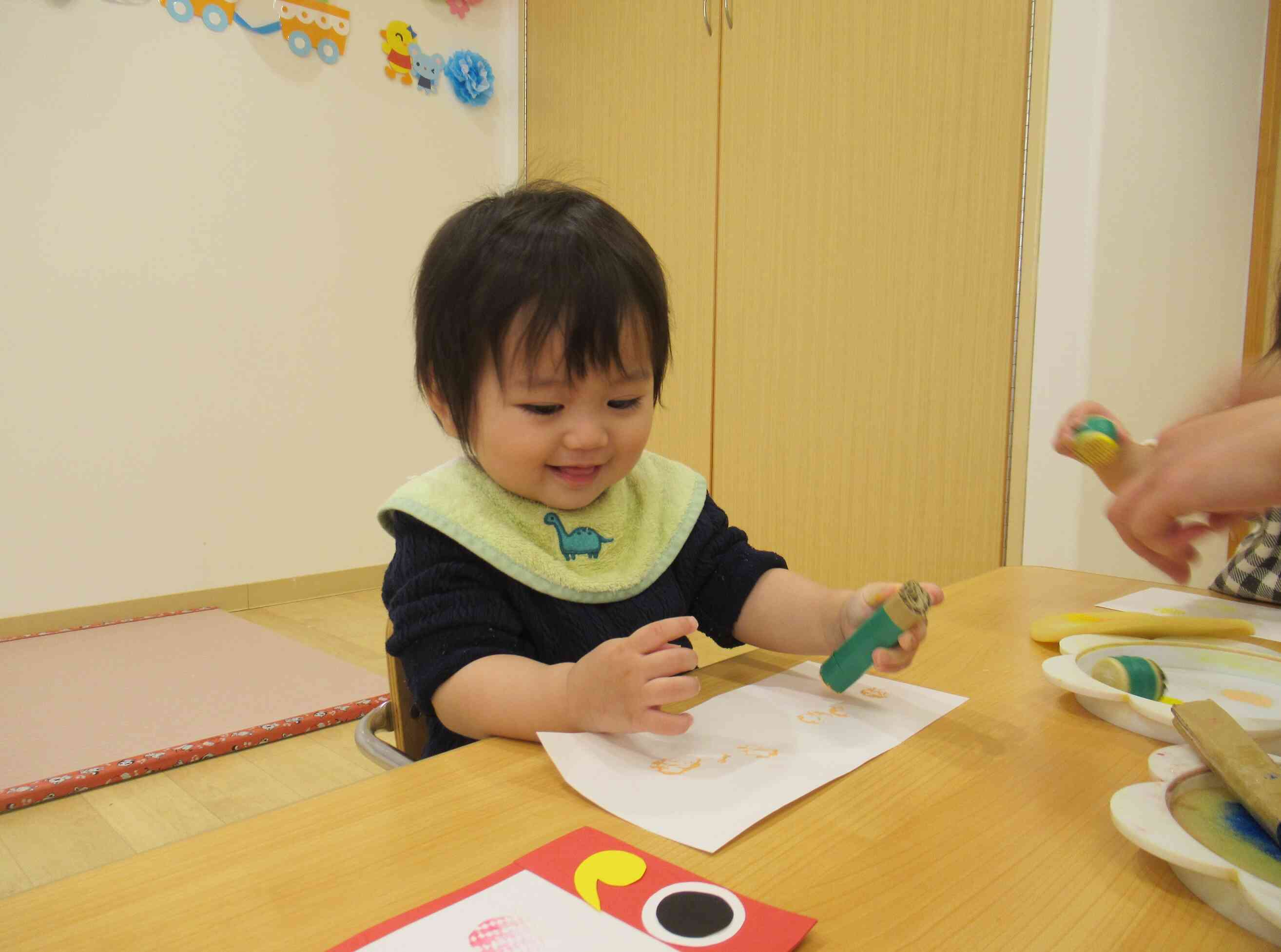 初めての製作遊び。画用紙に色がつき嬉しそうなあひる組（1歳児）のW君です。