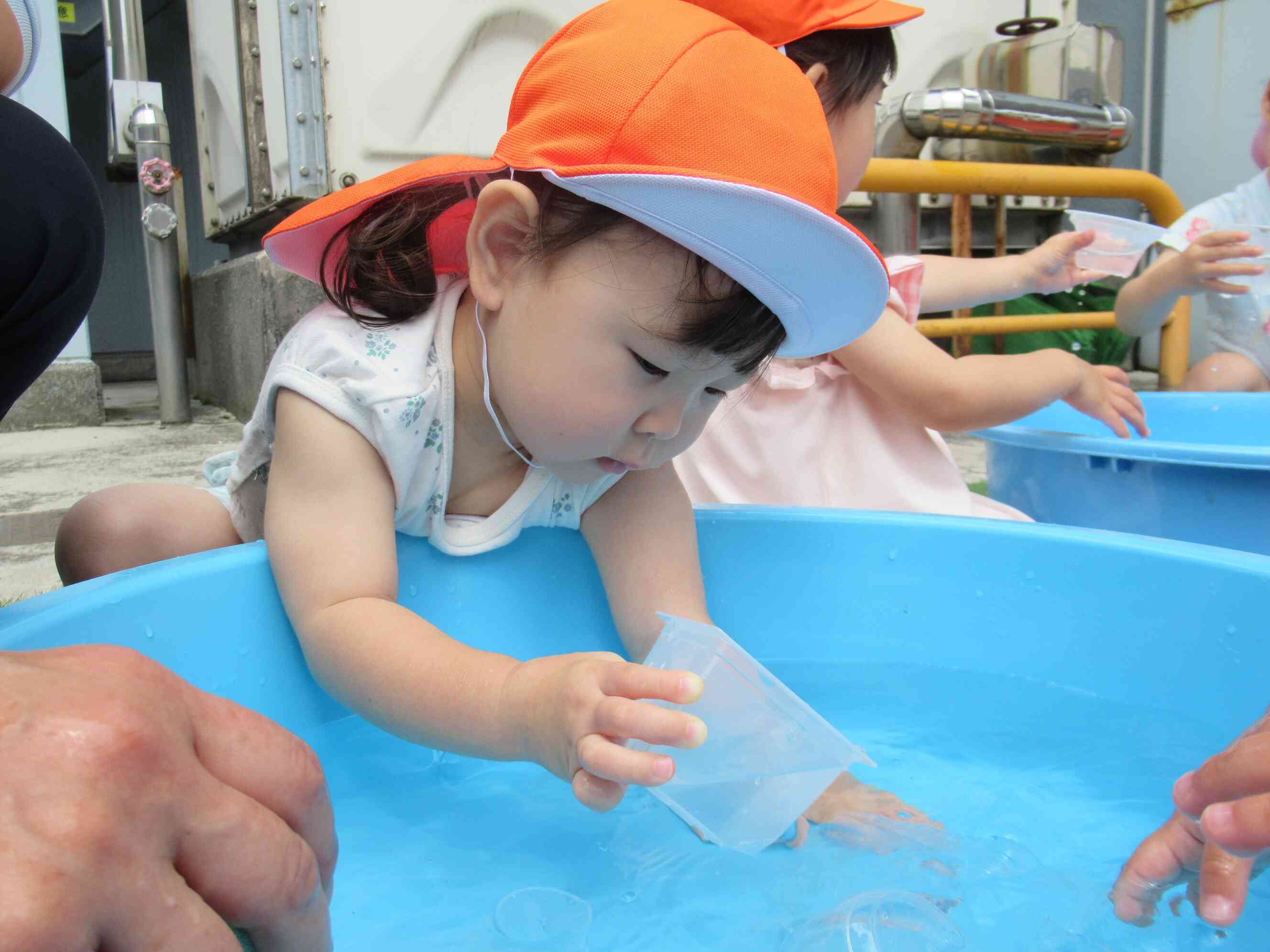 カップで水をすくったり流したり夢中で楽しむYちゃん。