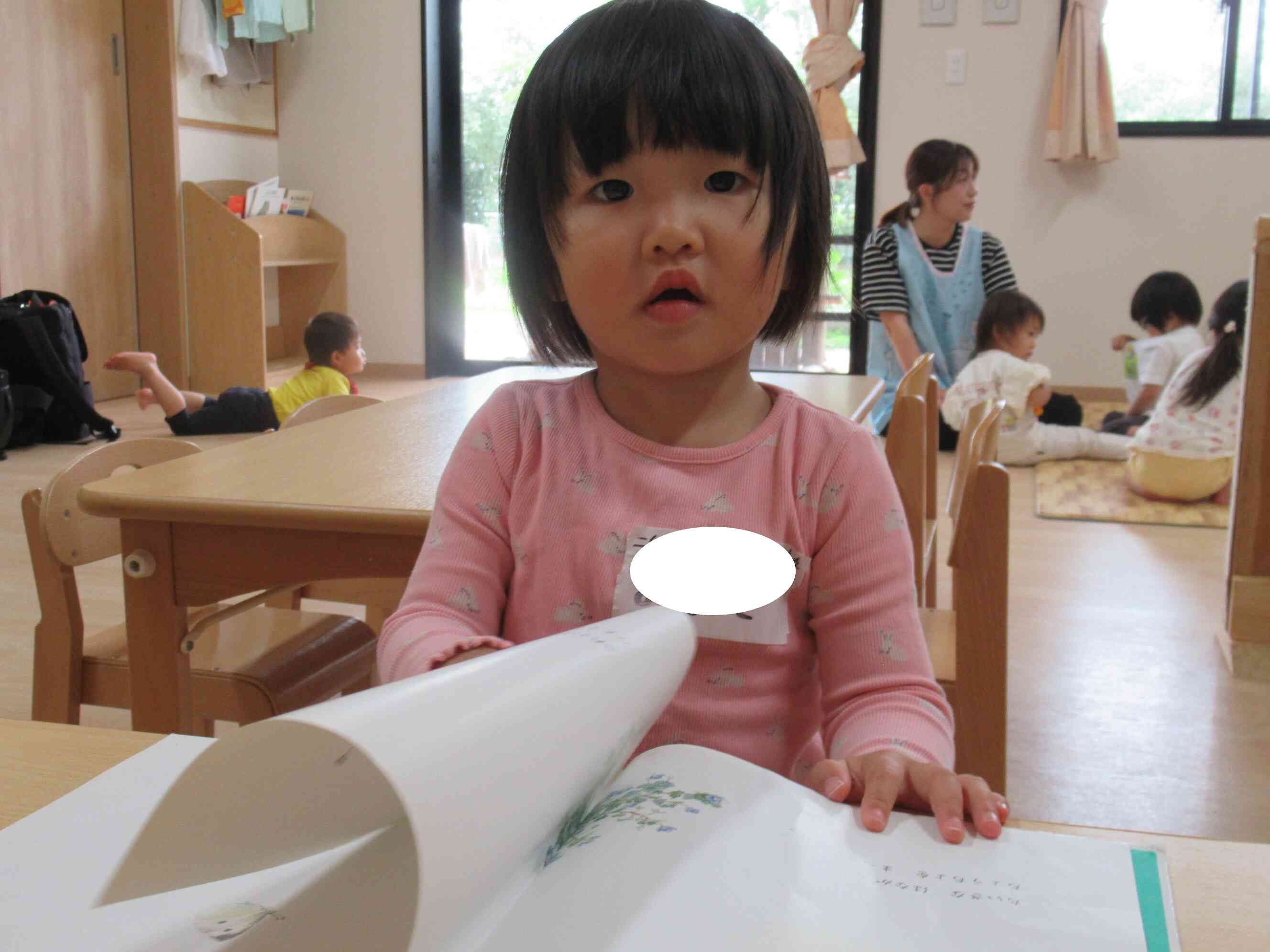 [せんせ～これ～」と保育園にもあるお気に入りの絵本を見つけて早速椅子に座って読み始めていたMちゃんでした。　