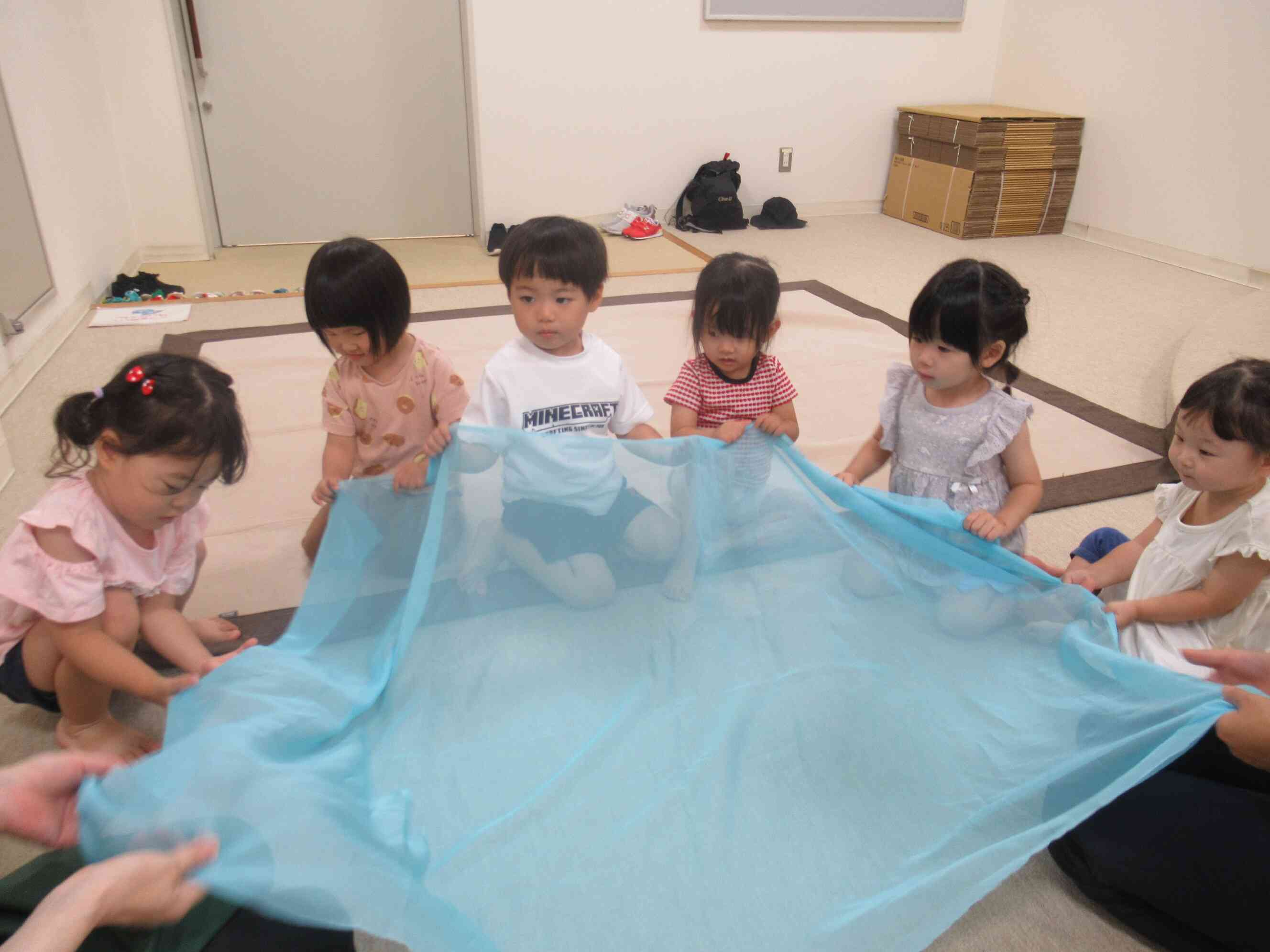 柔らかい布でにわらべ歌遊びです。海の波のようにユラユラと友だちと一緒に優しく揺らします