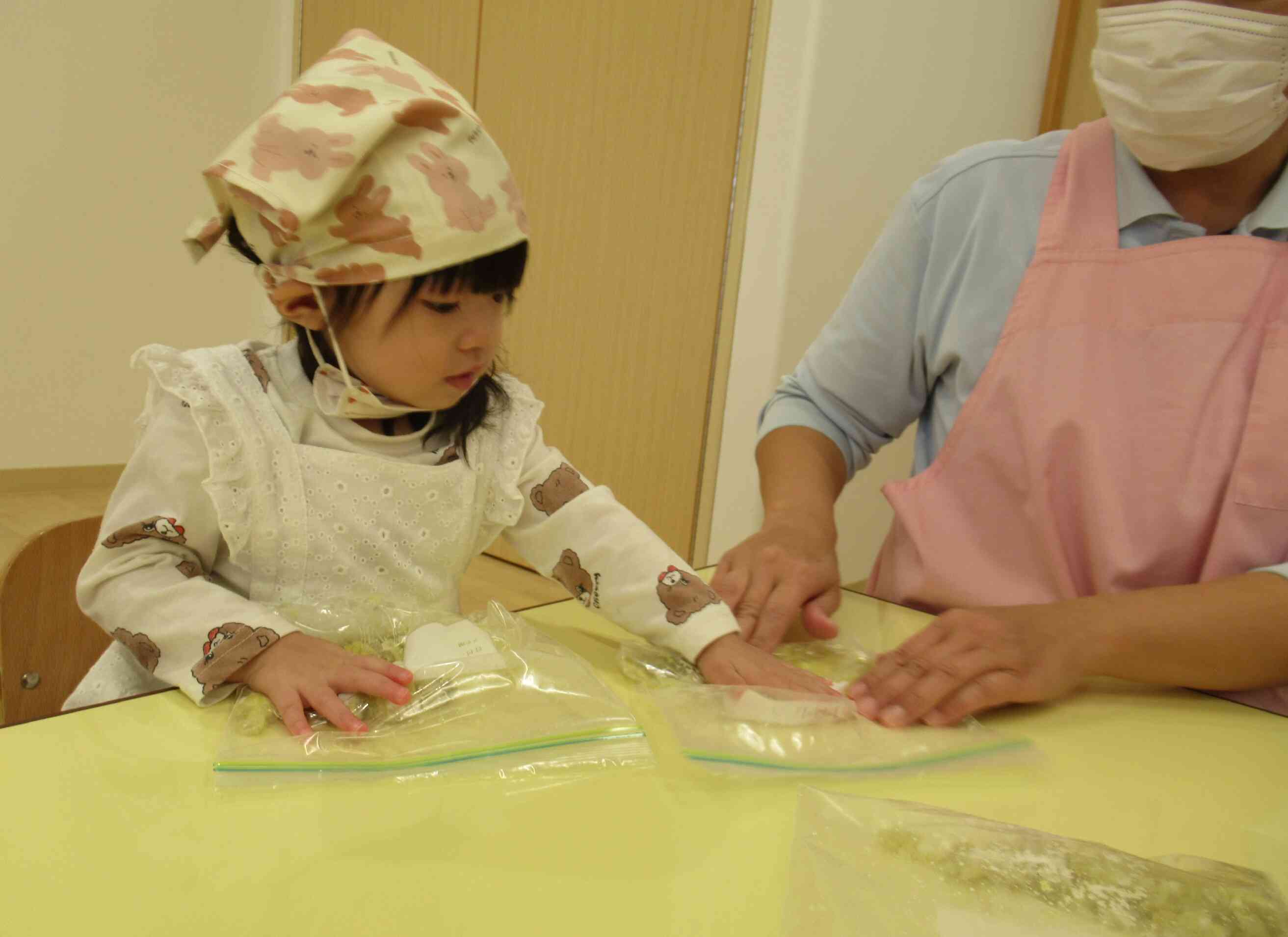 お芋を袋に入れて、しっかりとつぶすよ。せんせ~一緒にしよ~