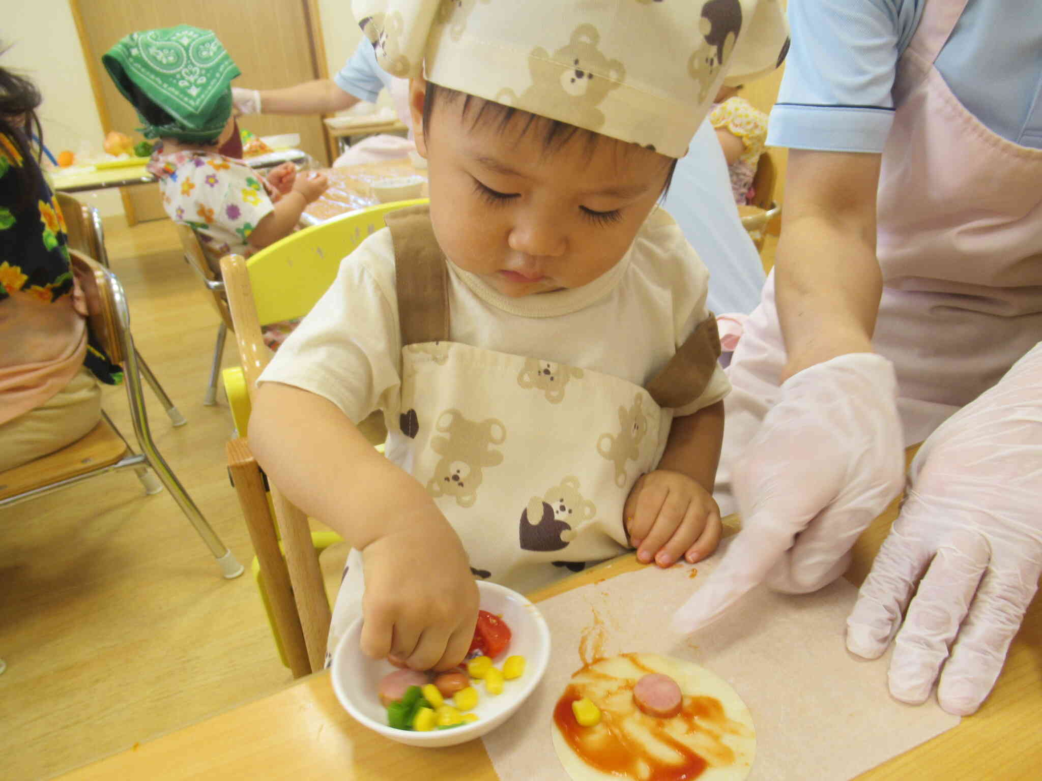 ０歳児のお友だちも上手ですね～。美味しいピザができそうです。