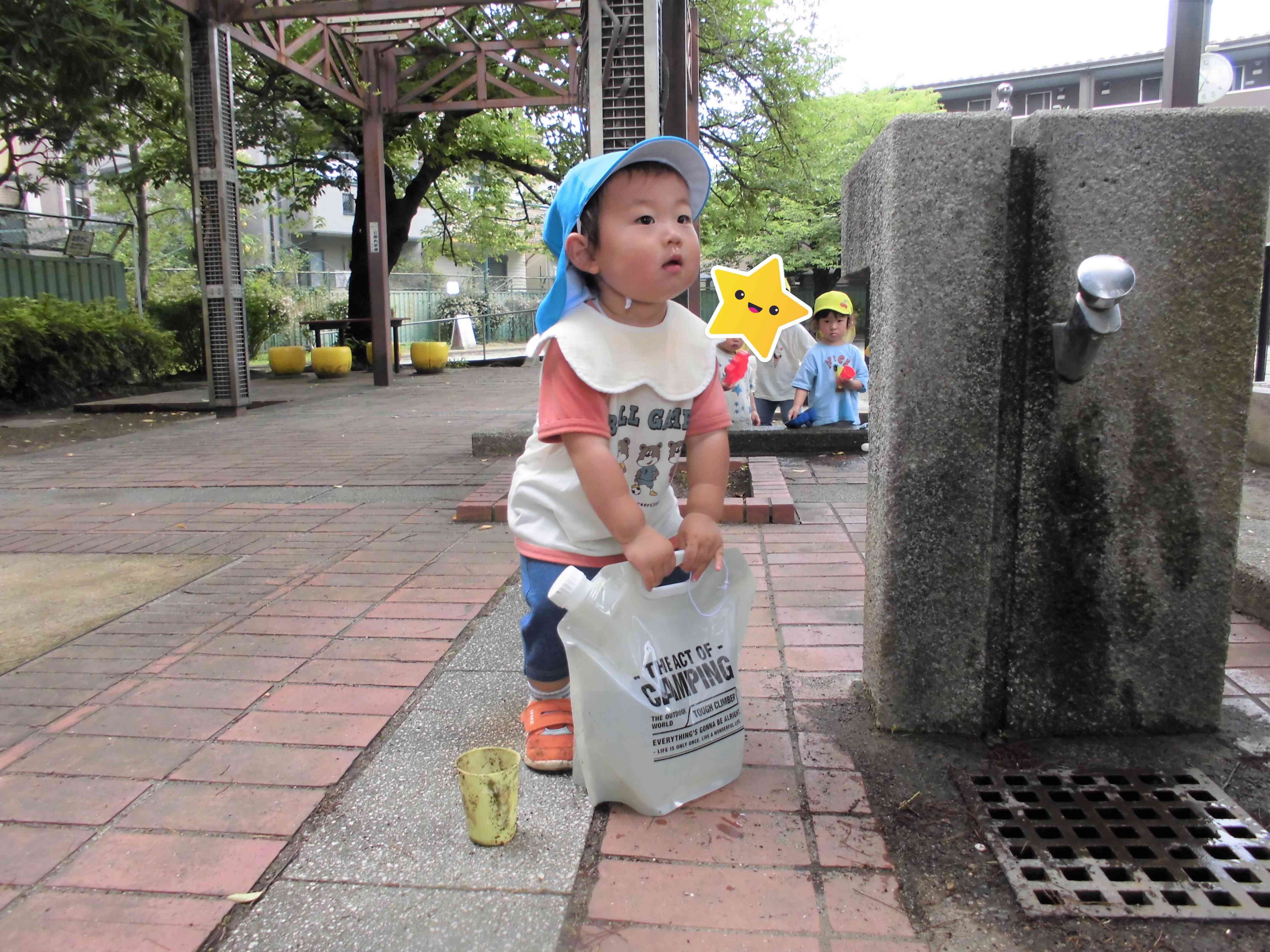 先生がくんだ水を持ち上げようと挑戦中！