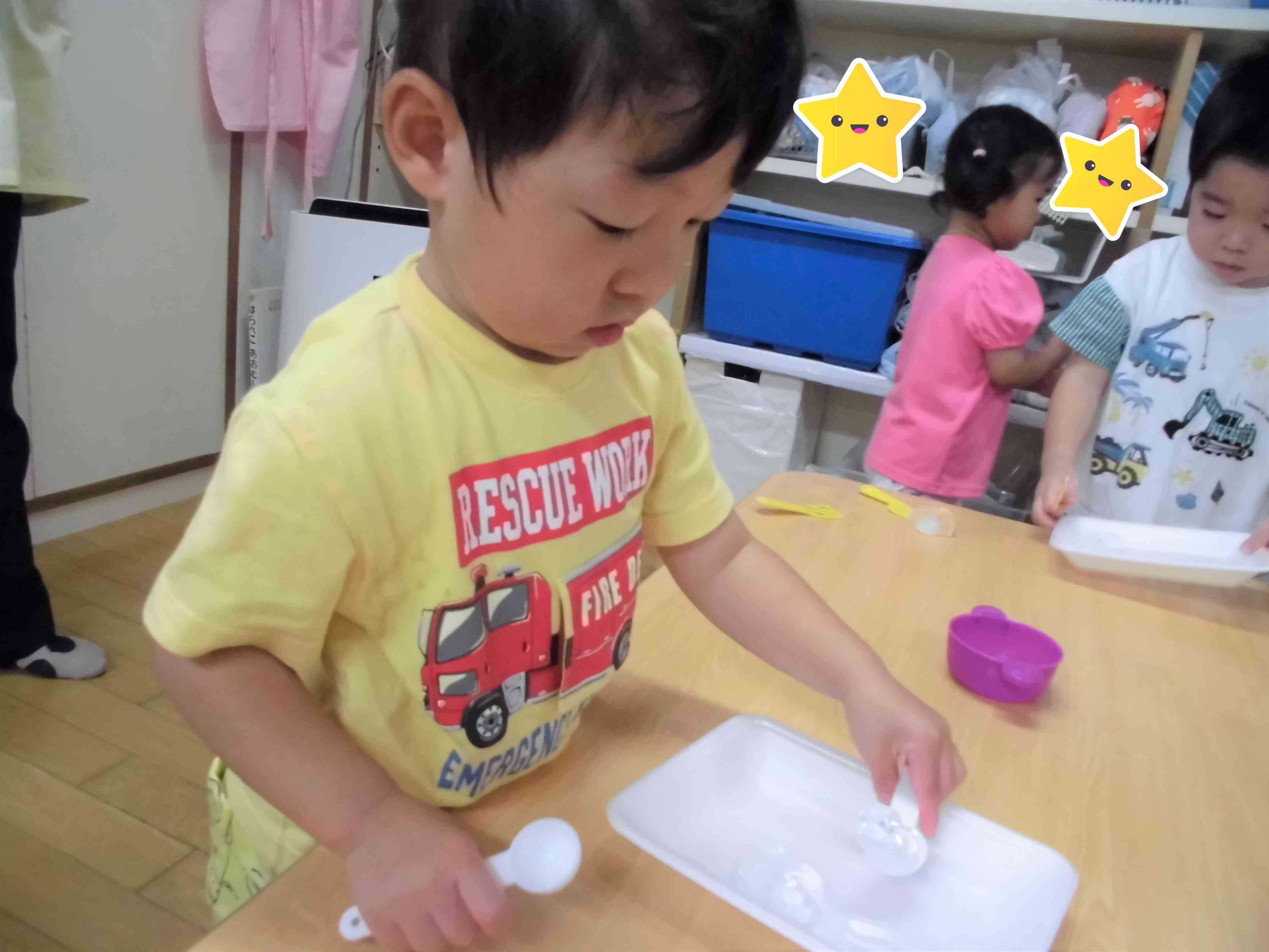 大さじスプーンを使って、つるつる滑る氷をすくおうと頑張っています！
